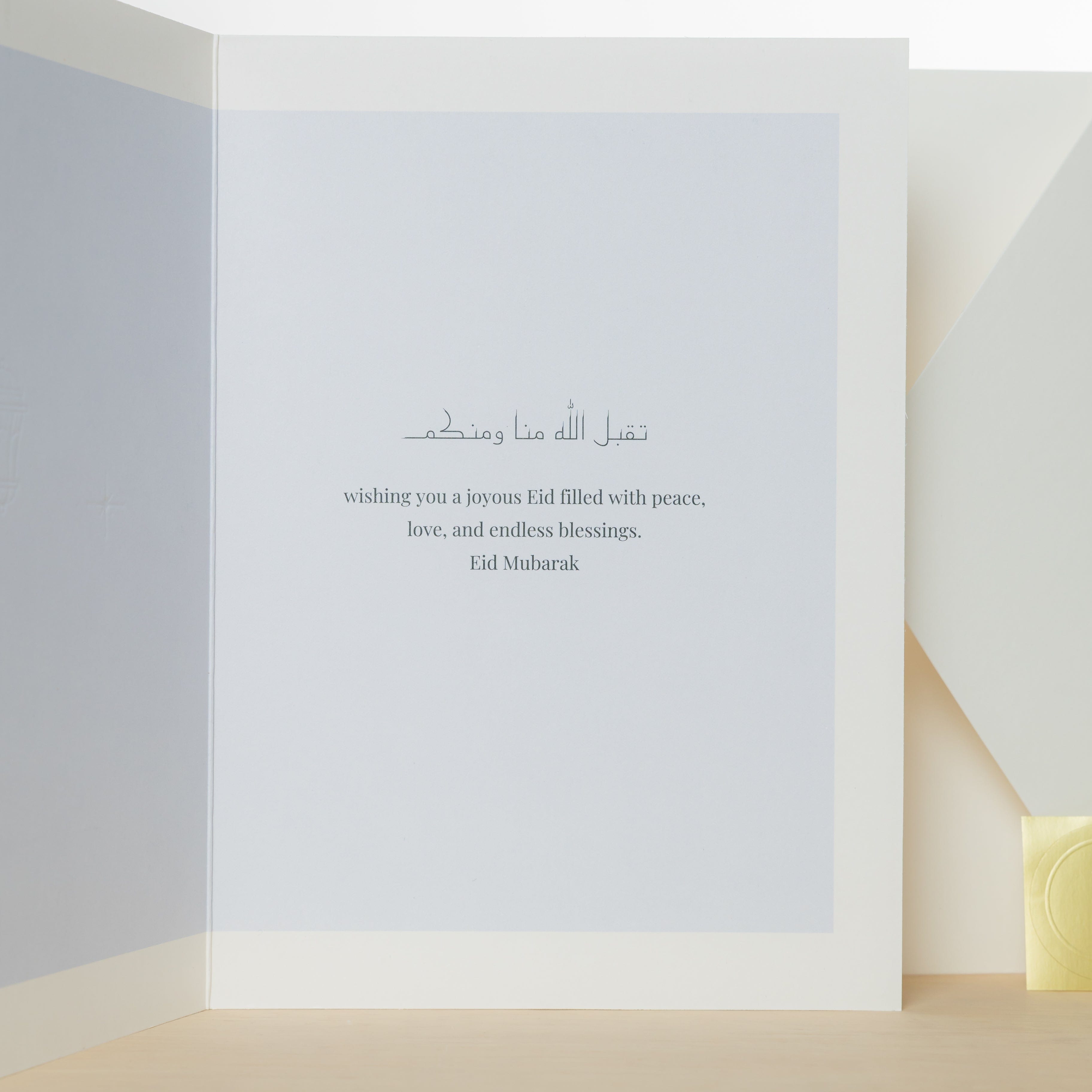 Eid greeting card displayed with a gift, emphasizing personal touch.