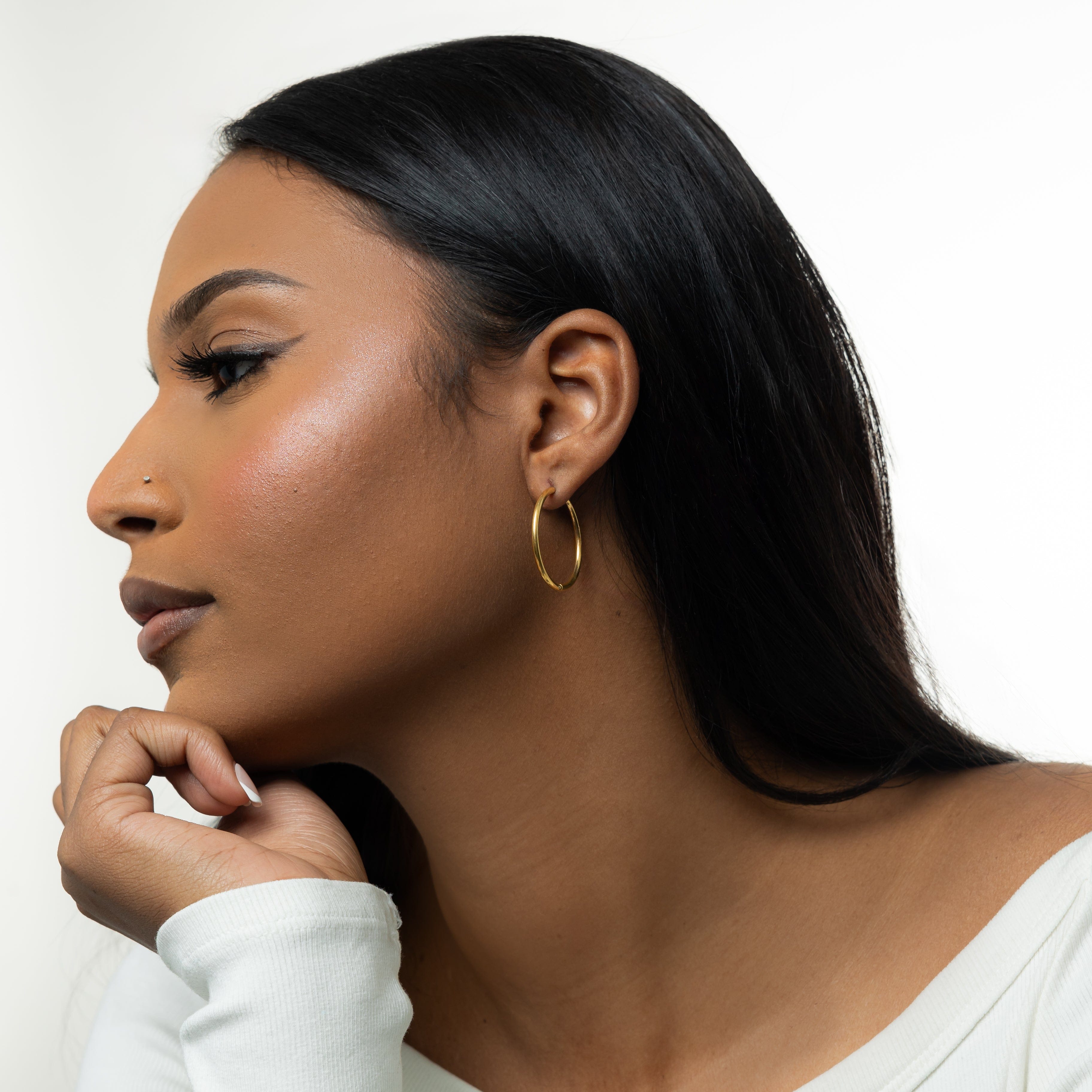 Close-up view of lightweight gold hoop earrings showing their shine and design.