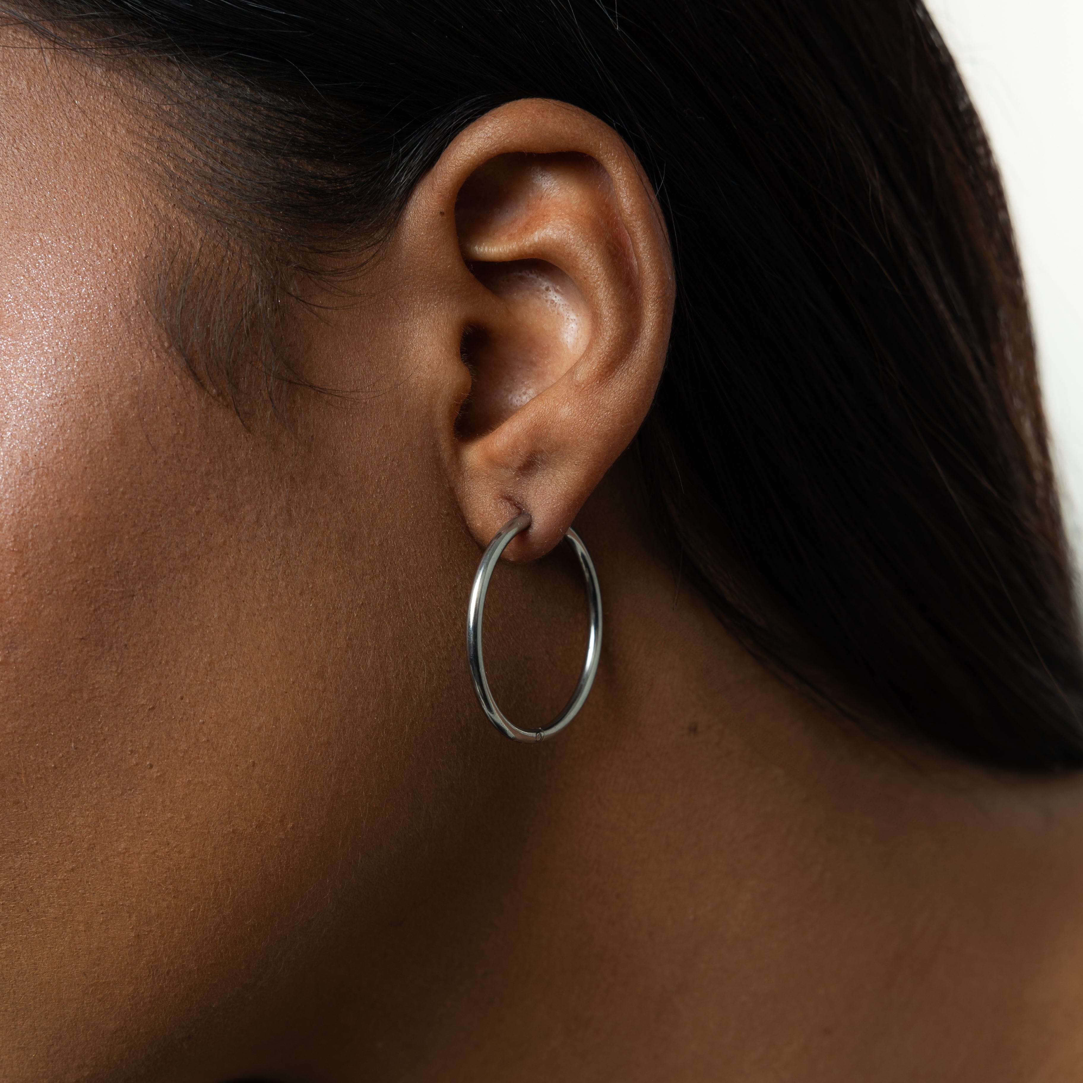 Close-up view of lightweight gold hoop earrings showing their shine and design.