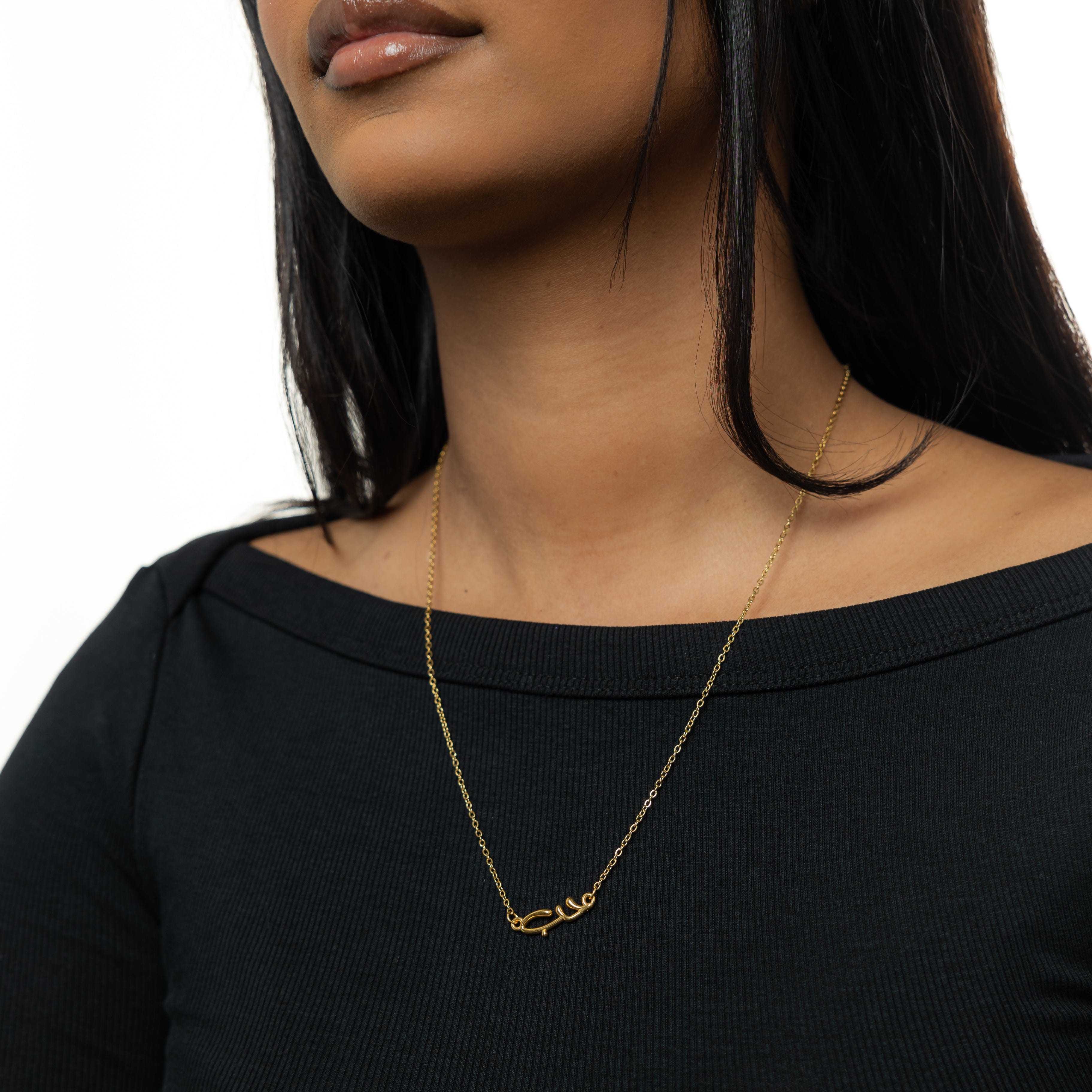 Close-up of the Arabic love bubble necklace showcasing its shiny gold plating and intricate design.