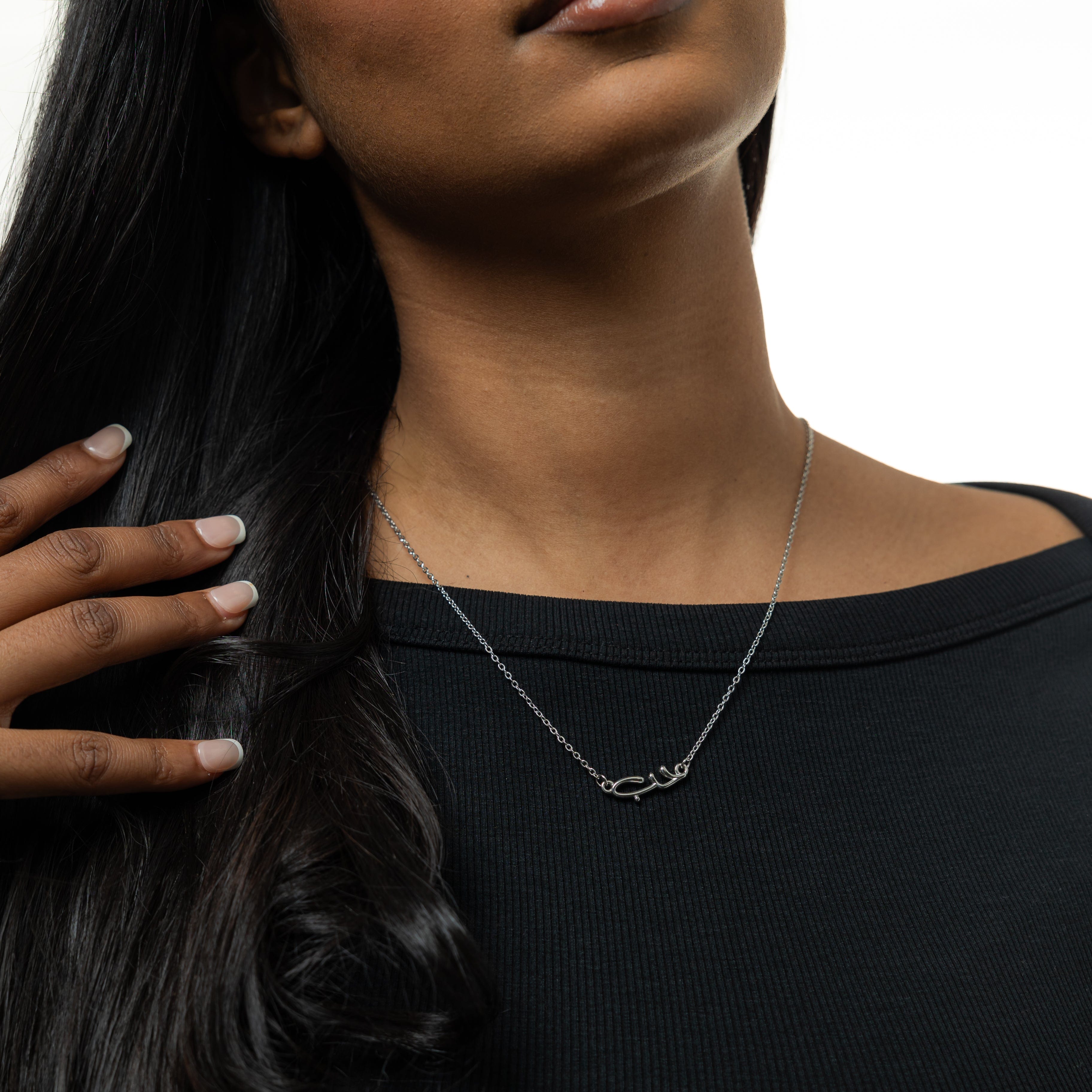 Close-up of the Arabic love bubble necklace showcasing its shiny gold plating and intricate design.