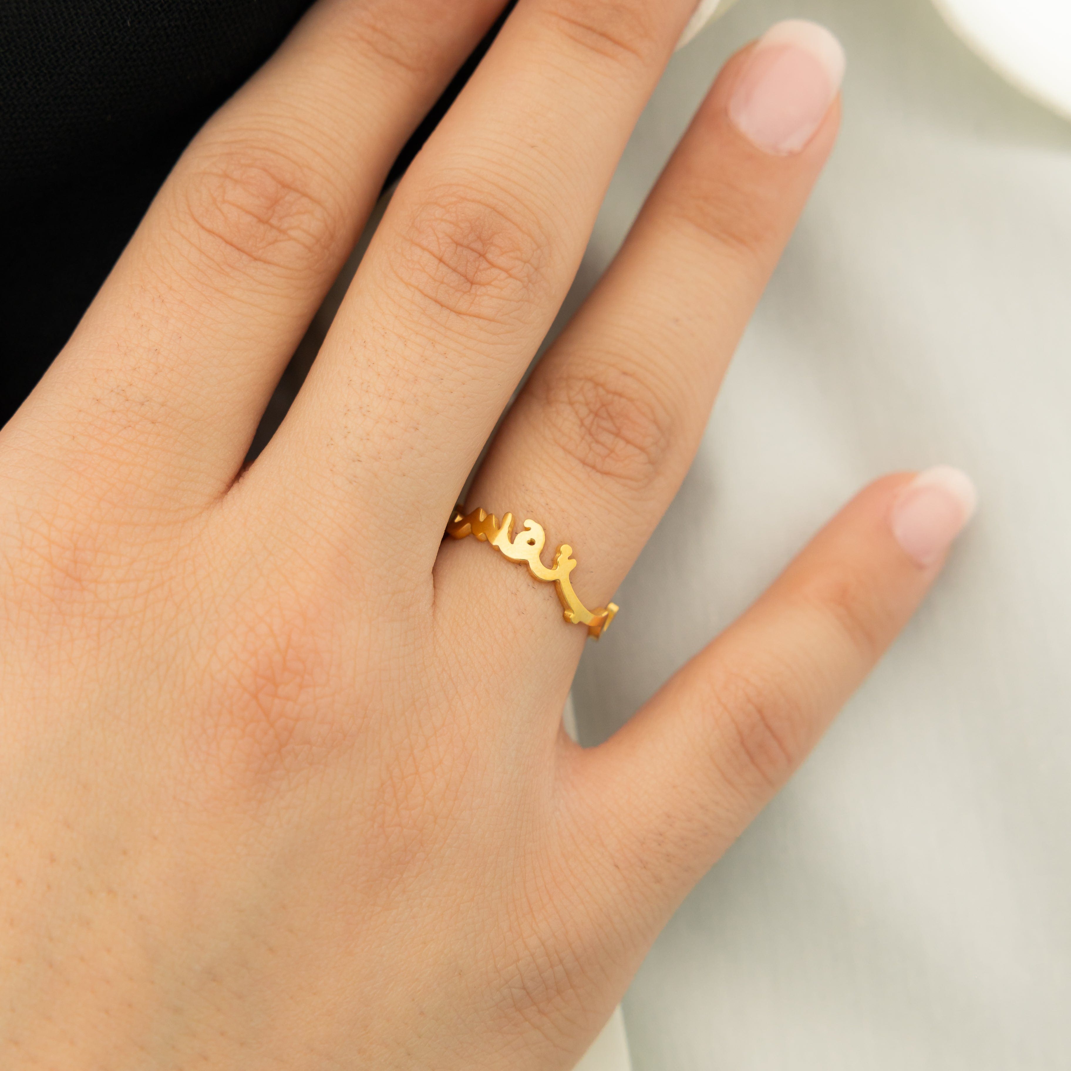 Close-up of the gold ring with Arabic script, emphasizing quality and craftsmanship.