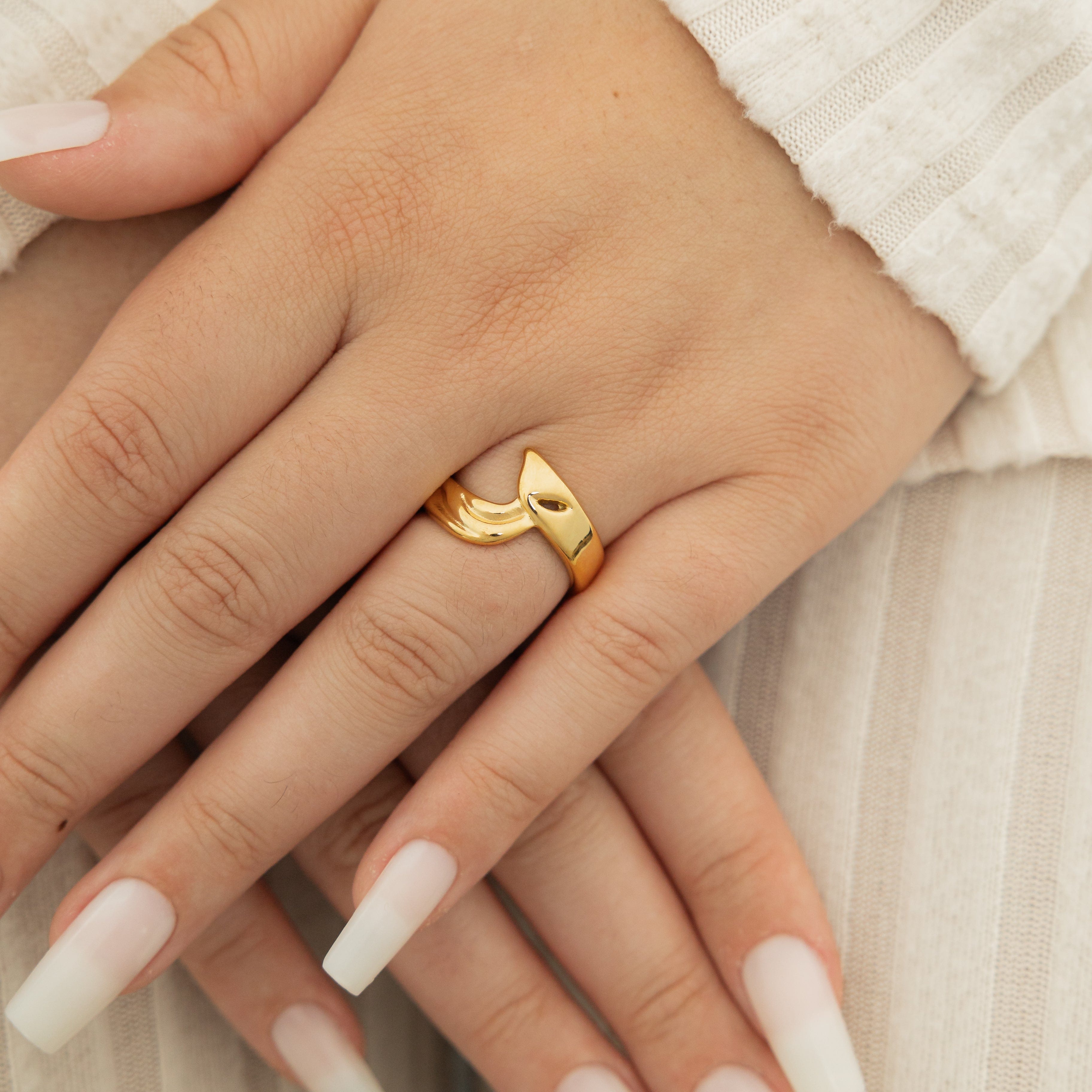 Close-up of the 18K gold love ring, highlighting its shiny finish and detail.