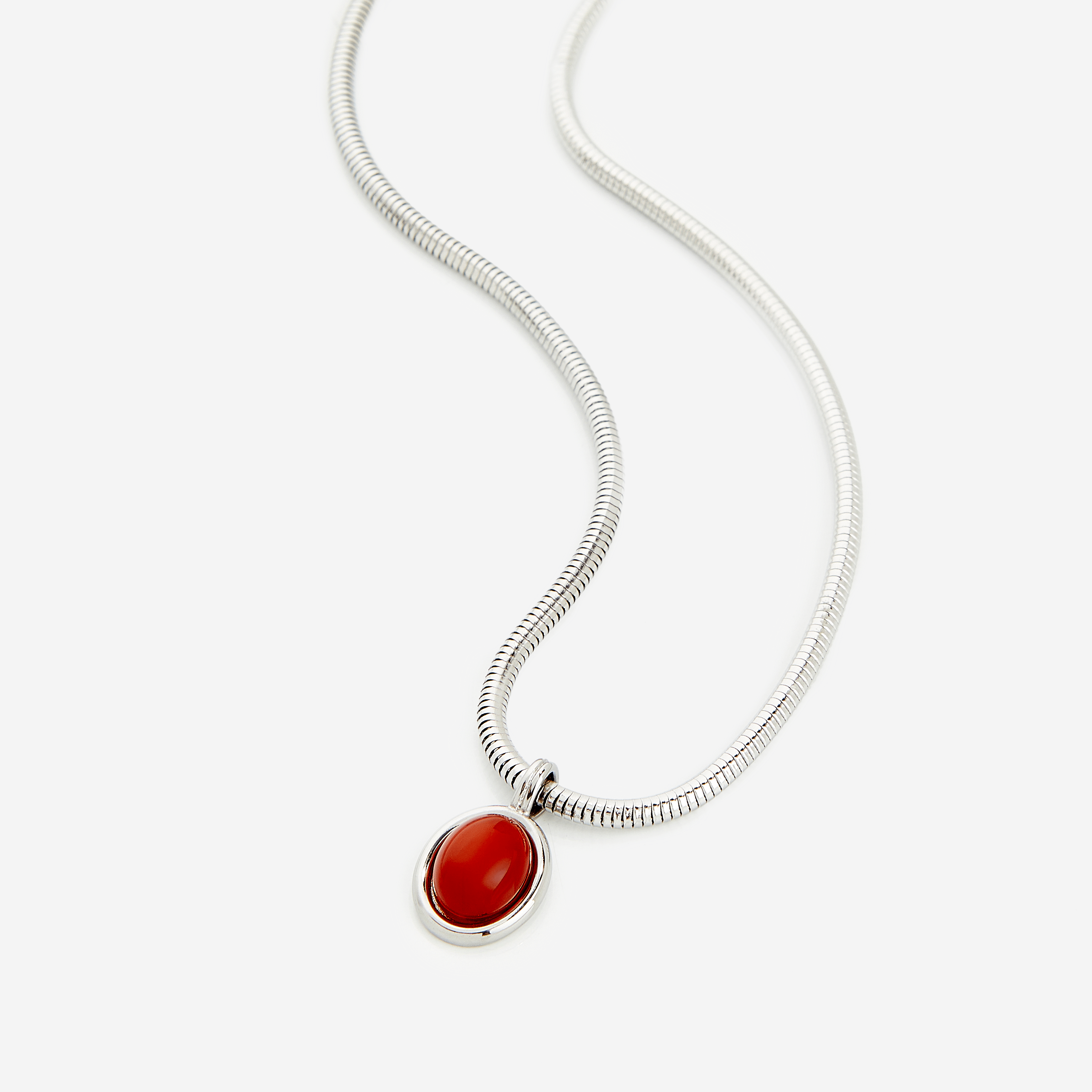 Men's red agate necklace displayed on a dark background, showcasing the steel pendant and harmony chain.