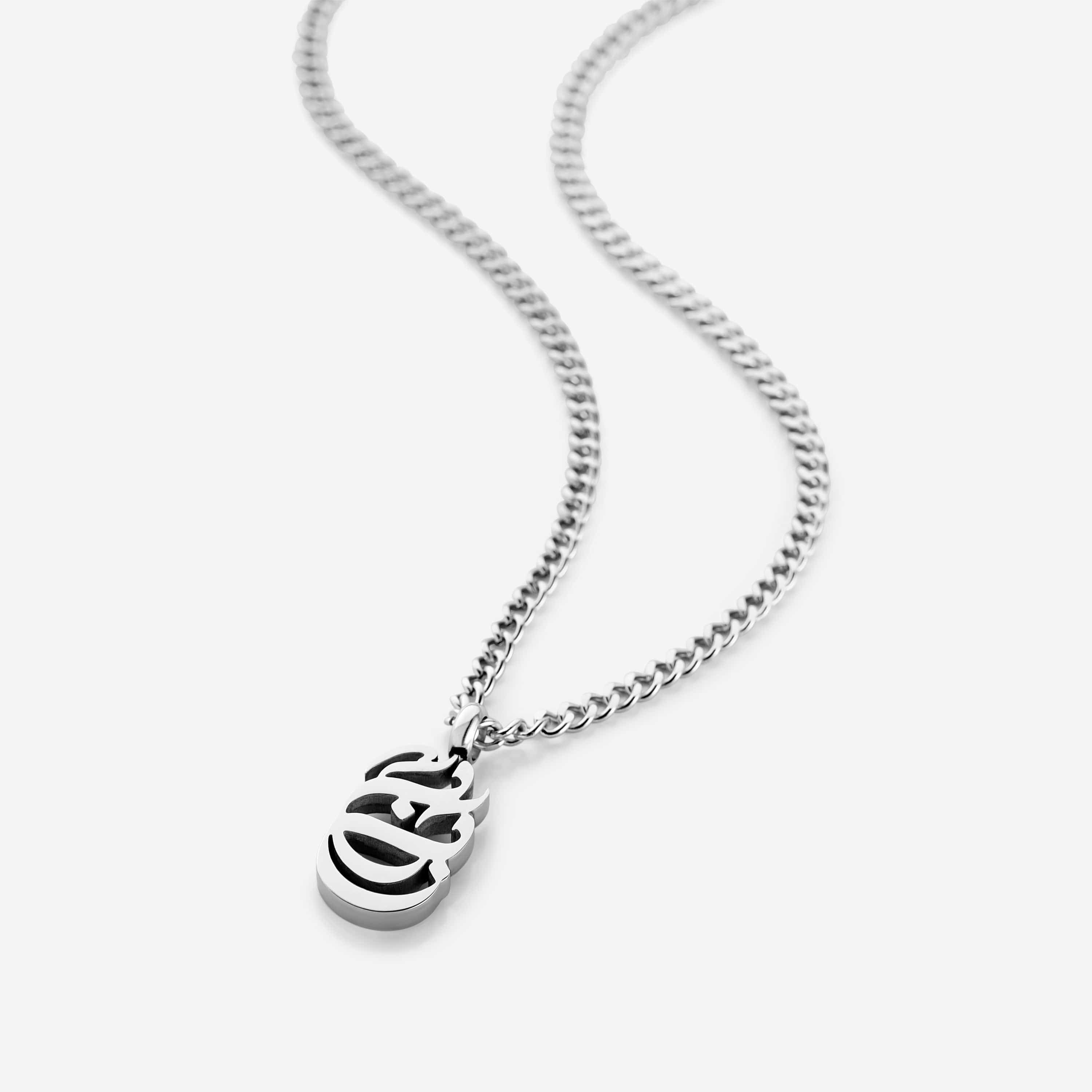 Baba Oval Arabic Calligraphy Necklace displayed on a wooden table