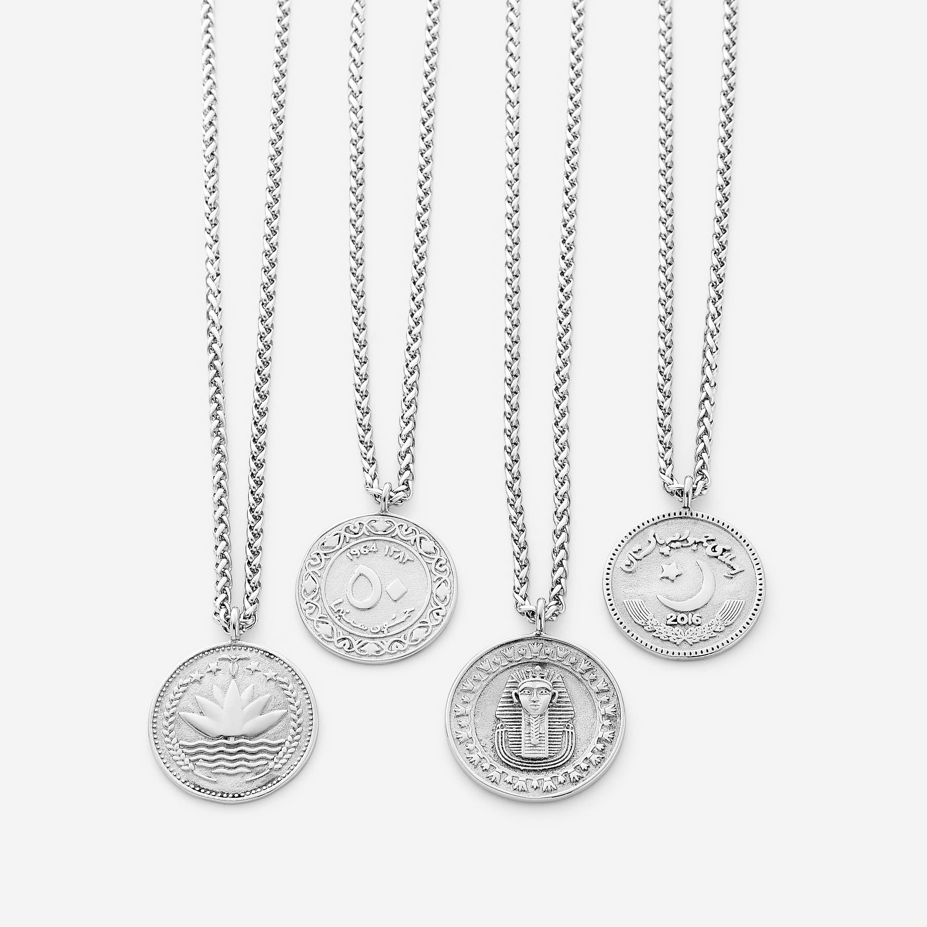 Close-up of the pendant on the mens necklace, showcasing the intricate country design against a soft surface.