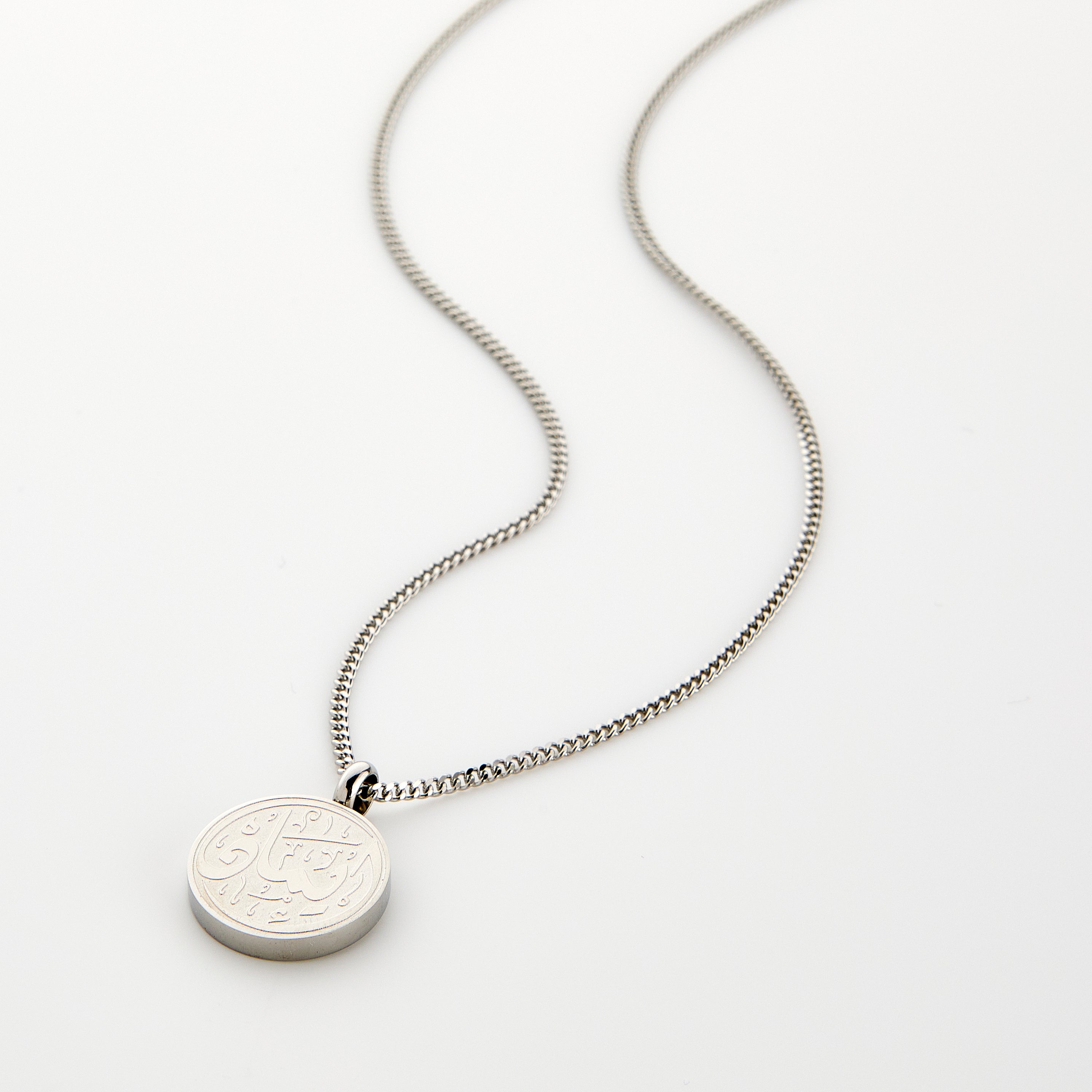 Close-up of the Iman engraved pendant necklace, highlighting the intricate calligraphy design.