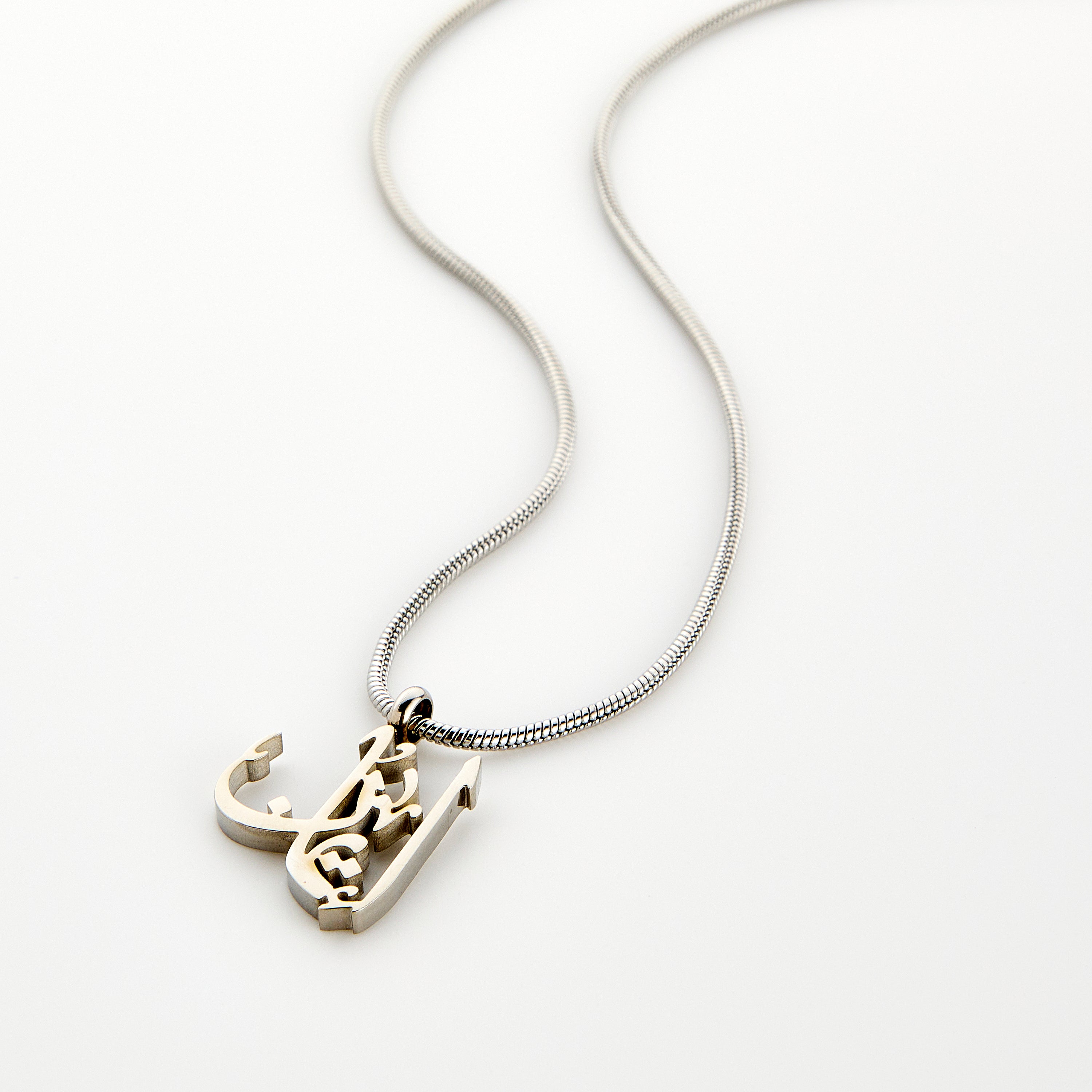 Close-up of the Timeless Faith Calligraphy Necklace showcasing Arabic calligraphy on stainless steel.
