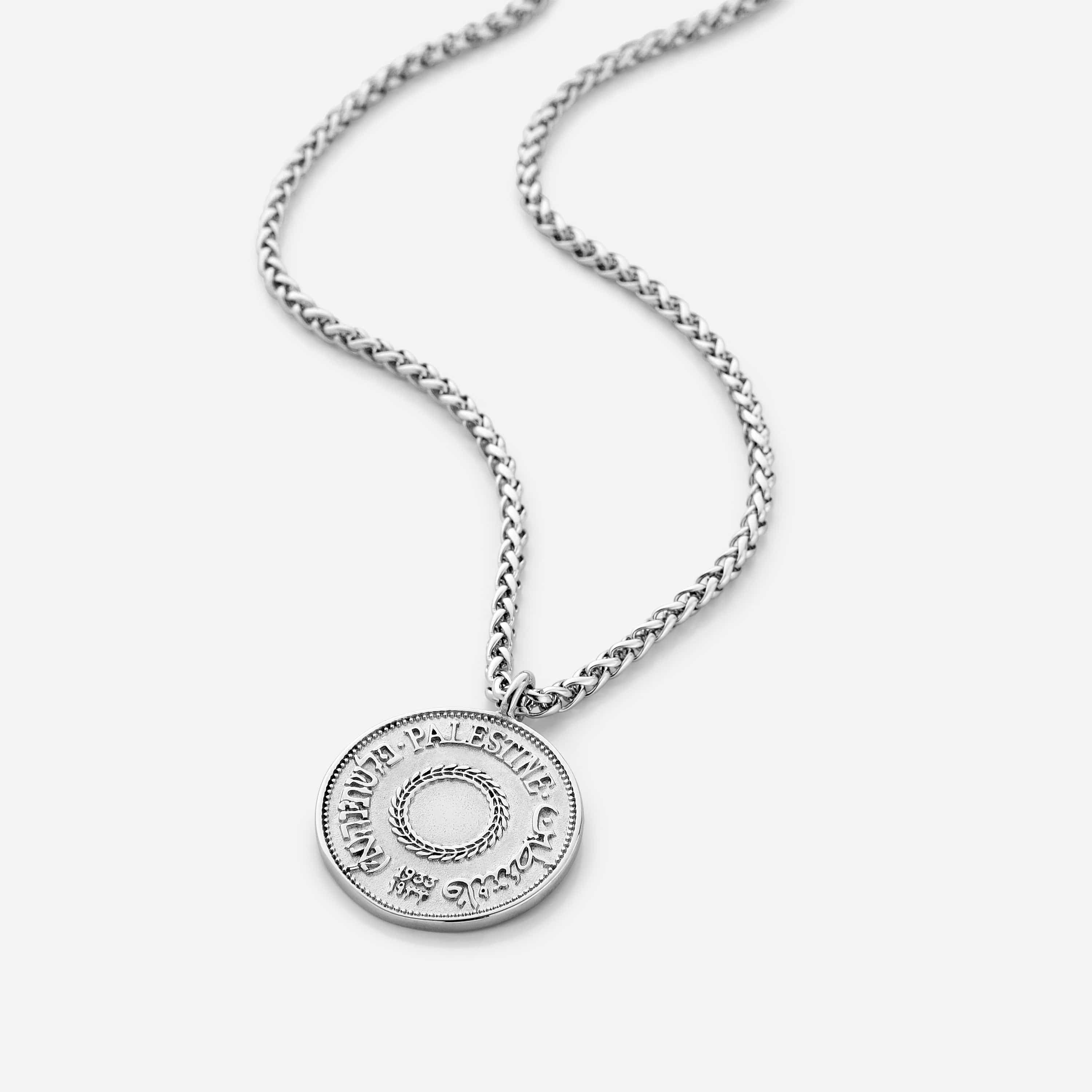 Front view of the authentic country coin necklace on a dark background, highlighting its wheat chain and pendant.