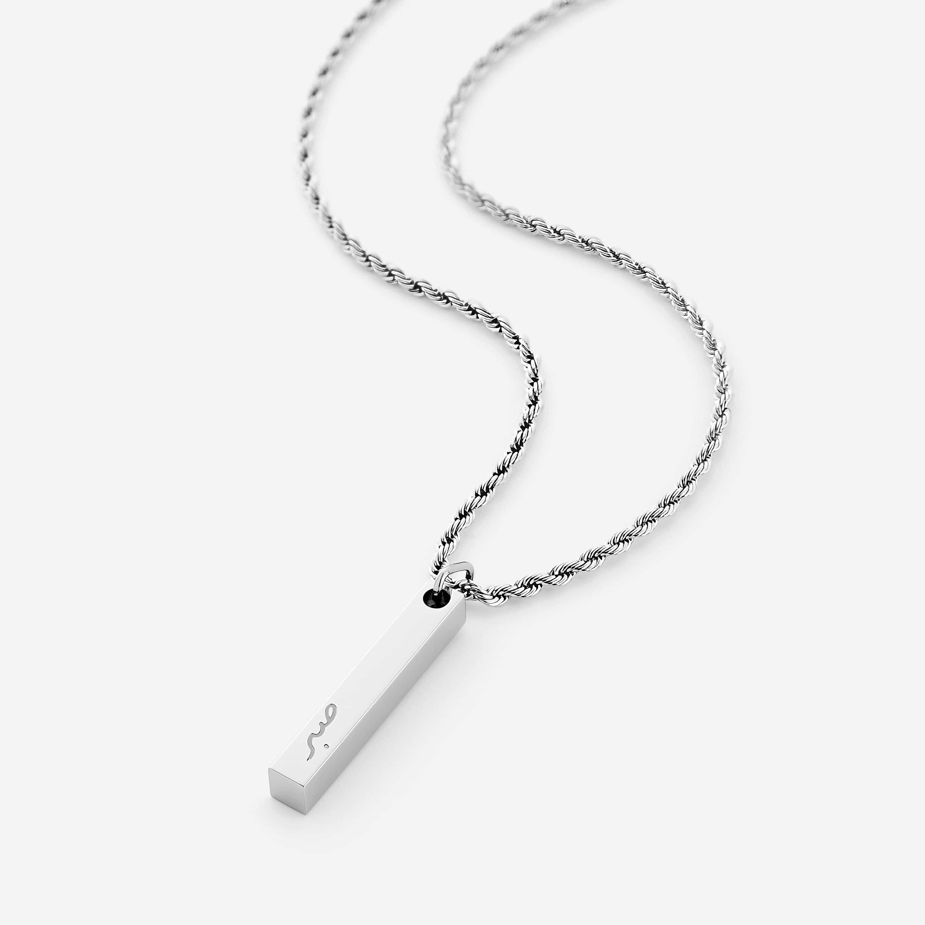 Close-up of the engraved patience gift necklace showcasing the Arabic inscription.