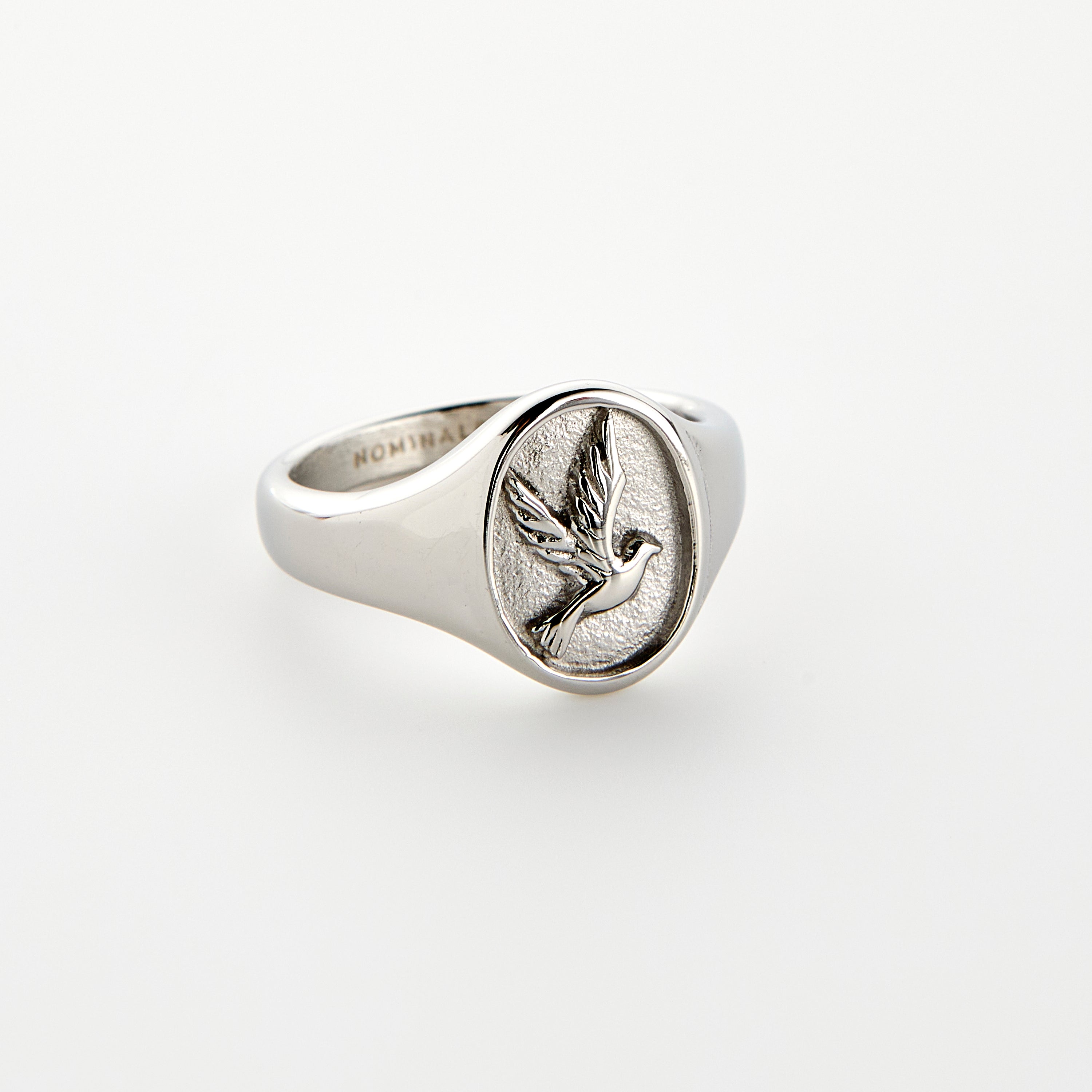 Close-up of men's dove ring showing embossed detailing and stainless steel finish