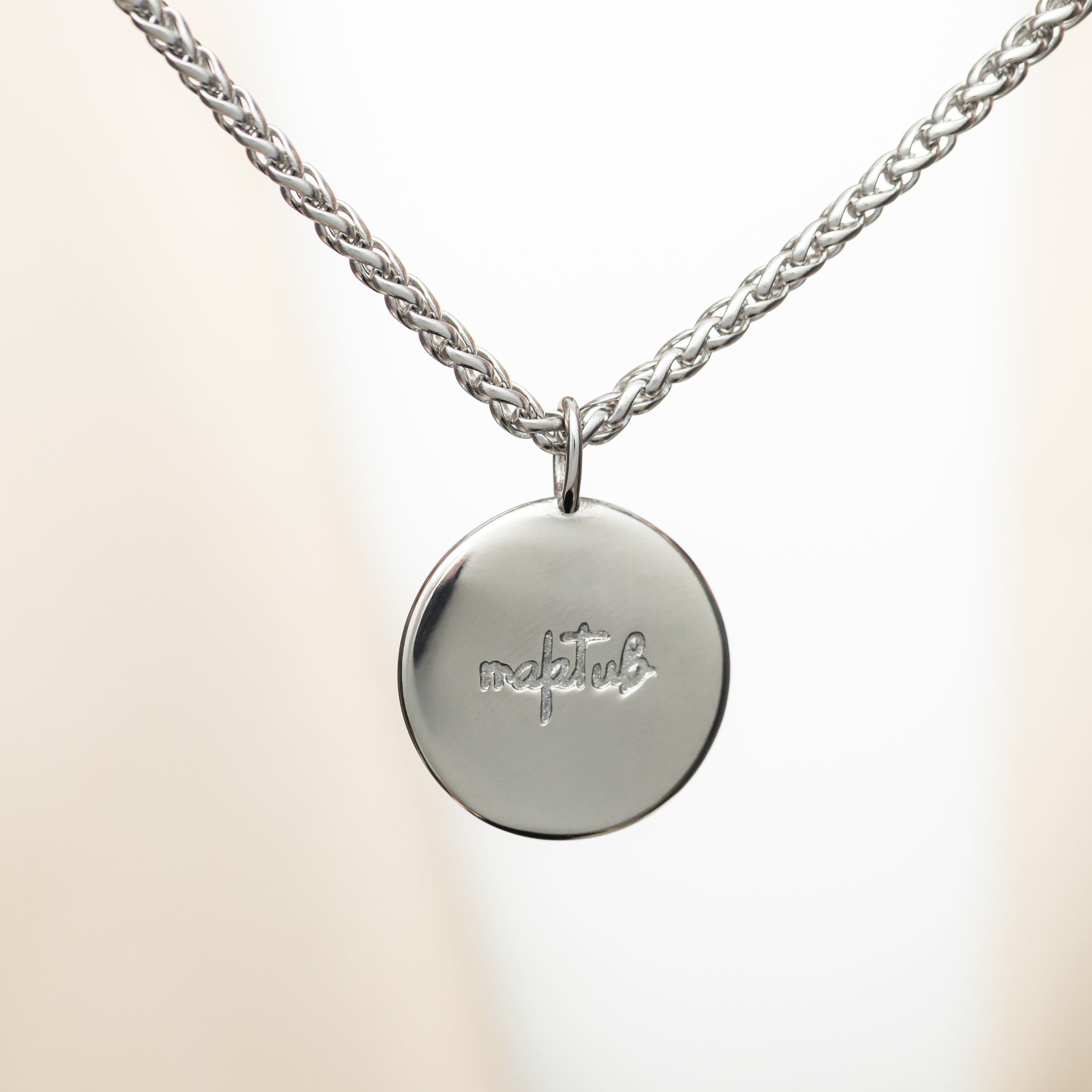 Maktub charm necklace displayed in a velvet pouch, emphasizing its gift-ready packaging.
