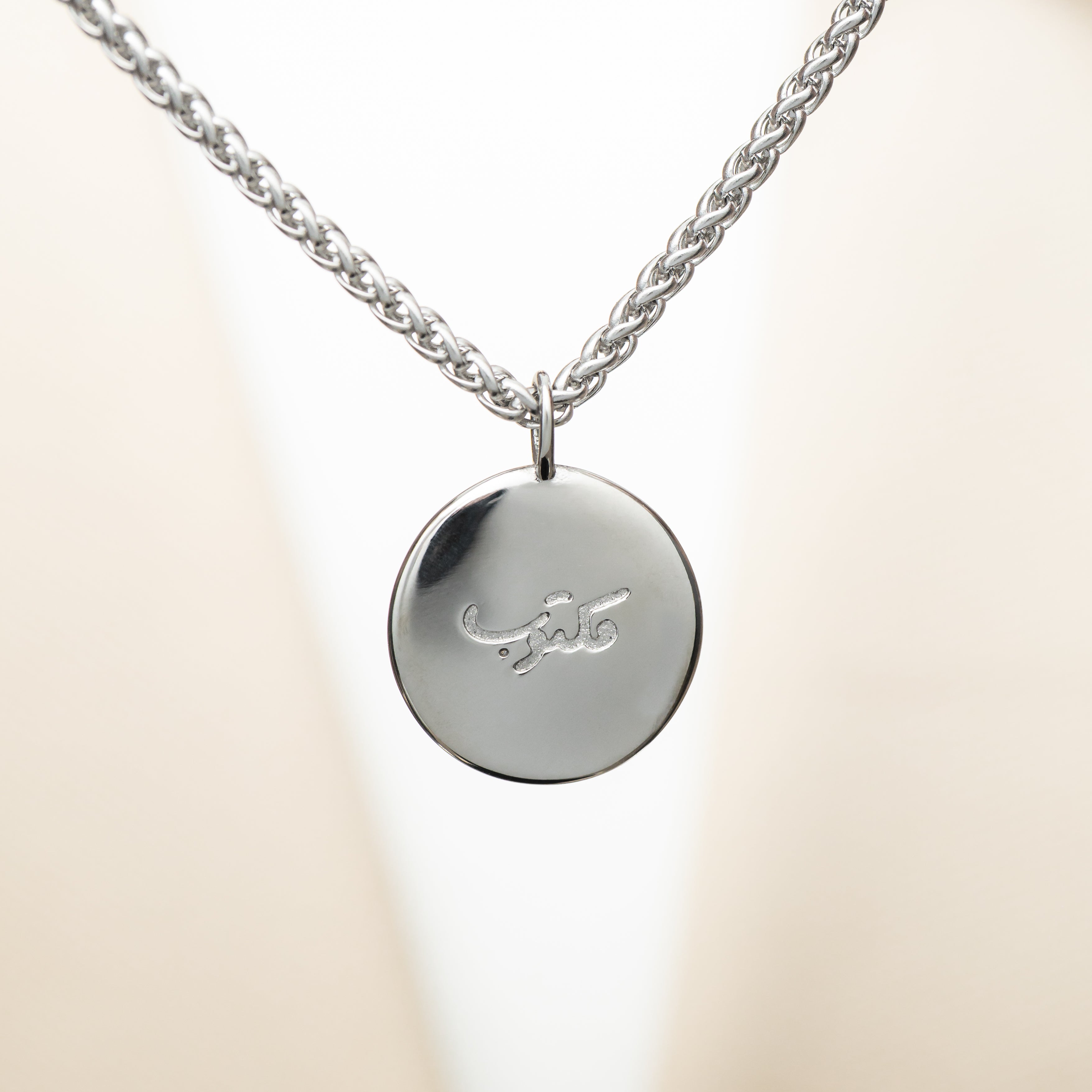 Front view of Maktub engraved charm necklace with Arabic engraving.