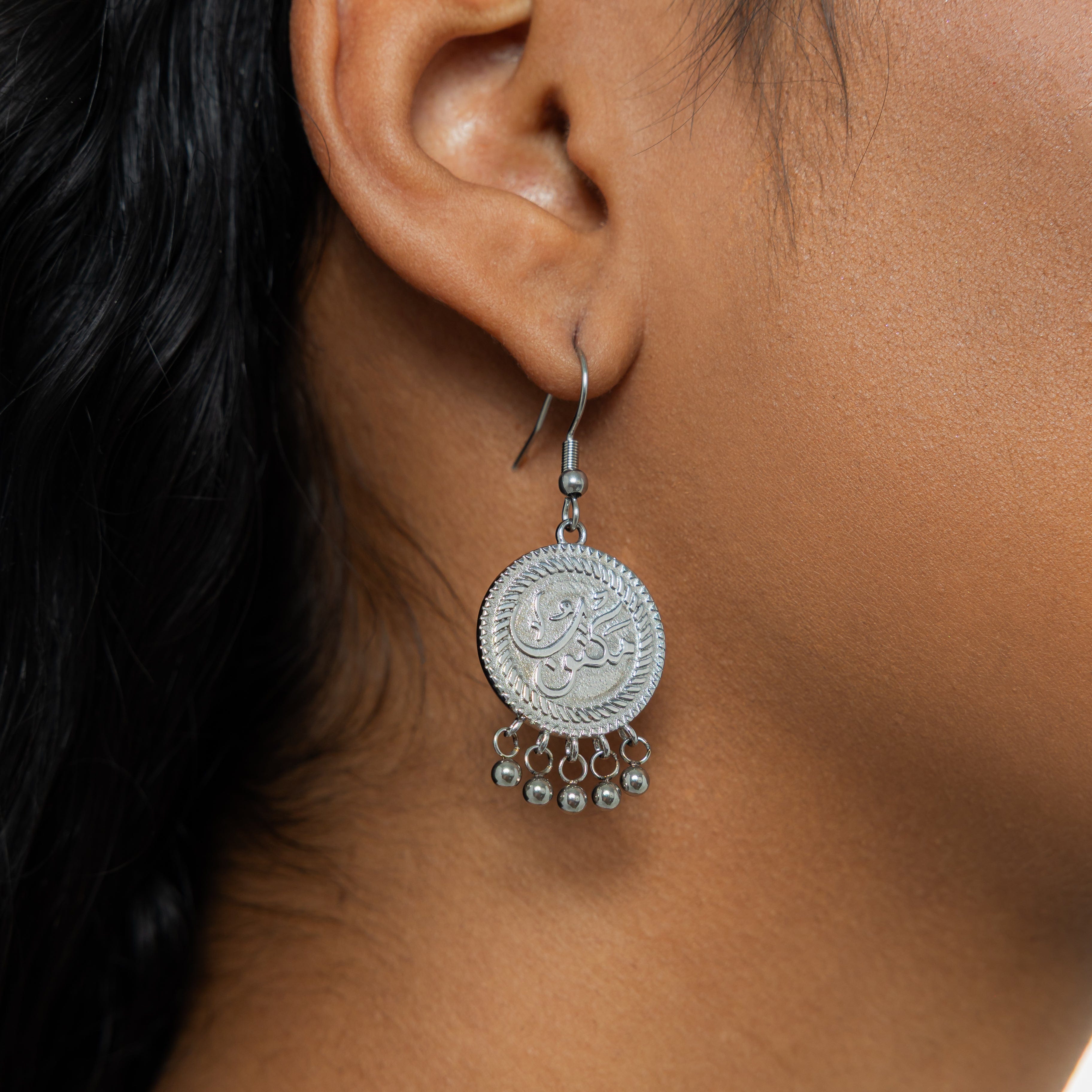 Lifestyle shot of vintage coin earrings being worn, highlighting their movement and shimmer.