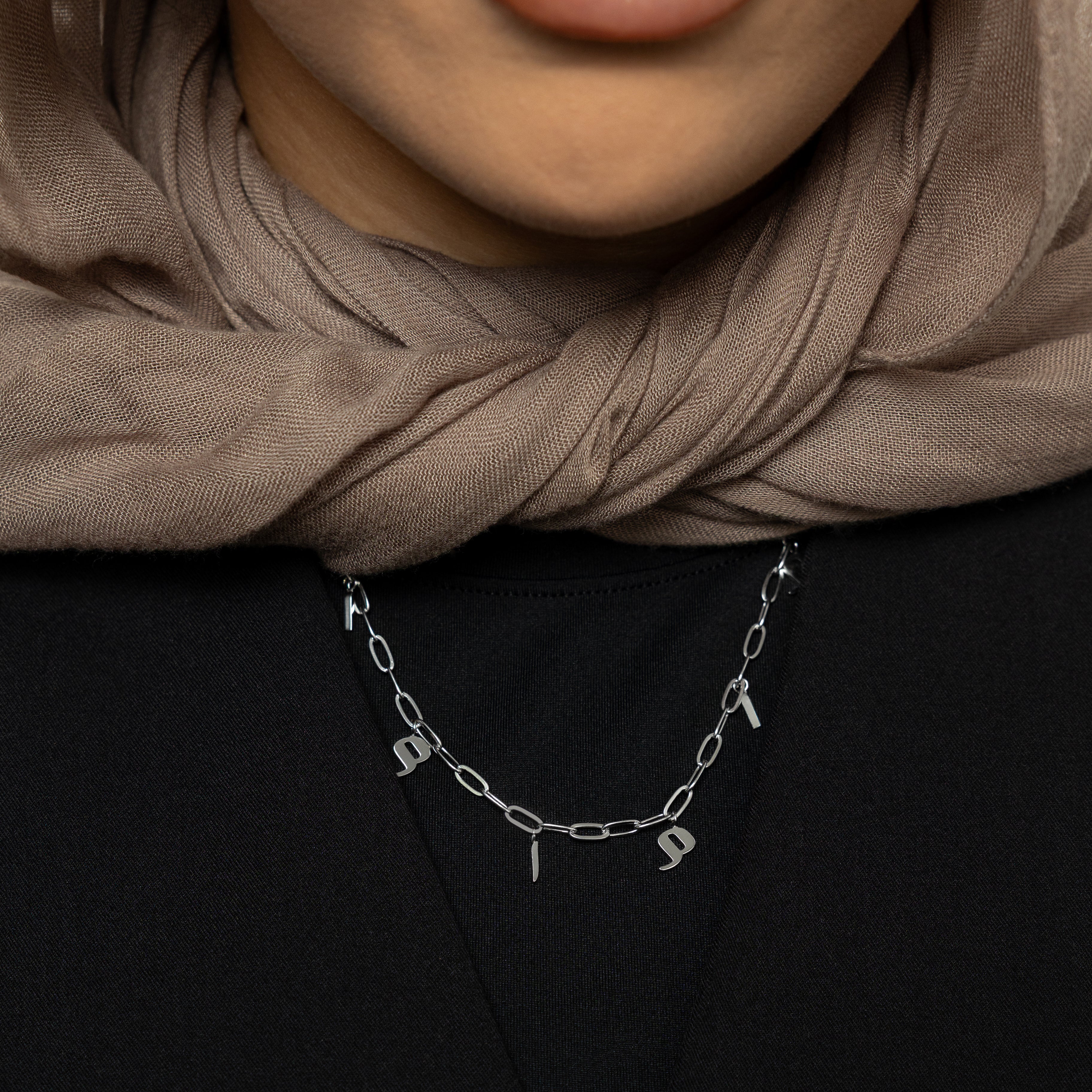 Close-up of the personalized mama charm necklace showcasing its elegant gold finish and Arabic letters.