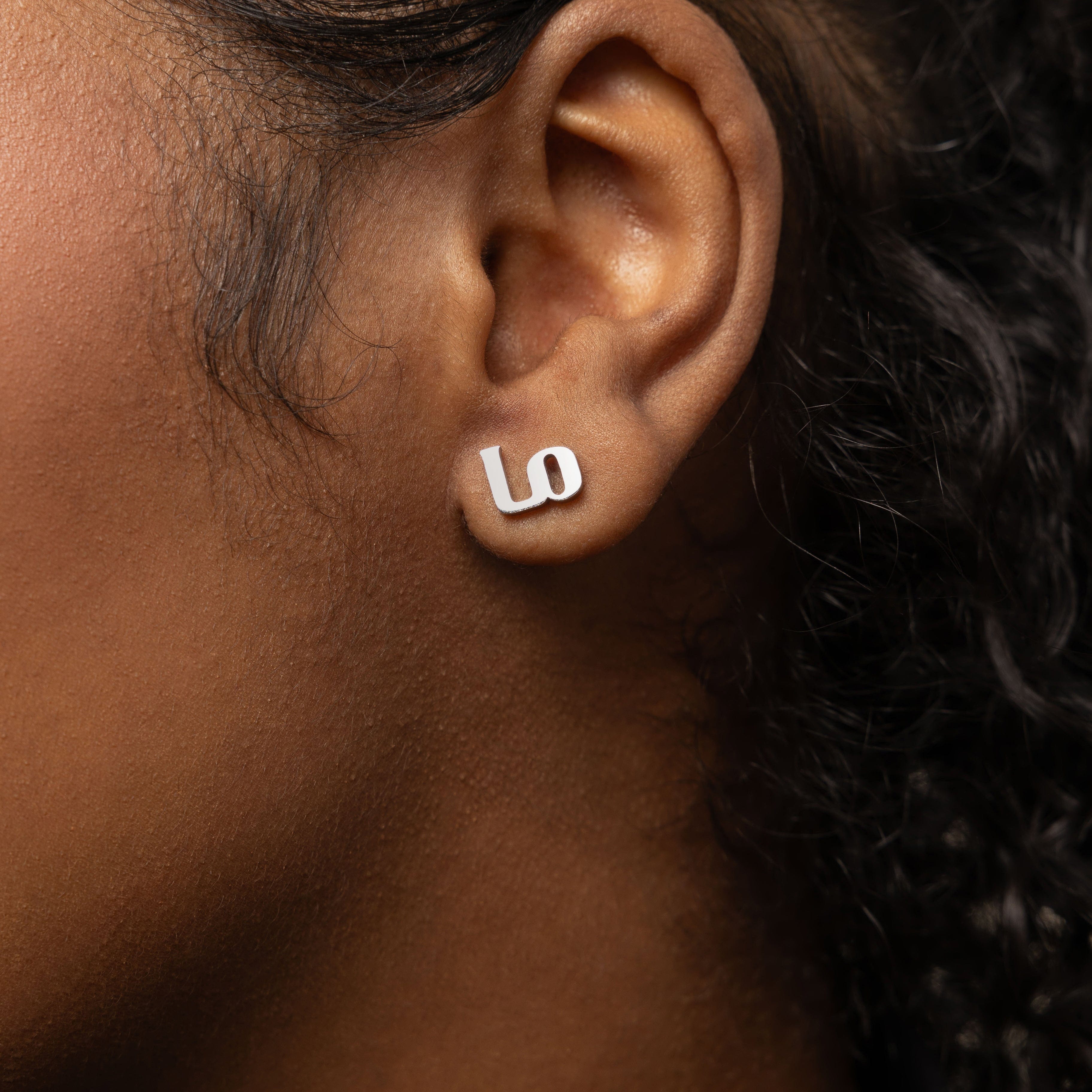 Close-up view of Mama Love minimalist earrings showcasing Arabic calligraphy.