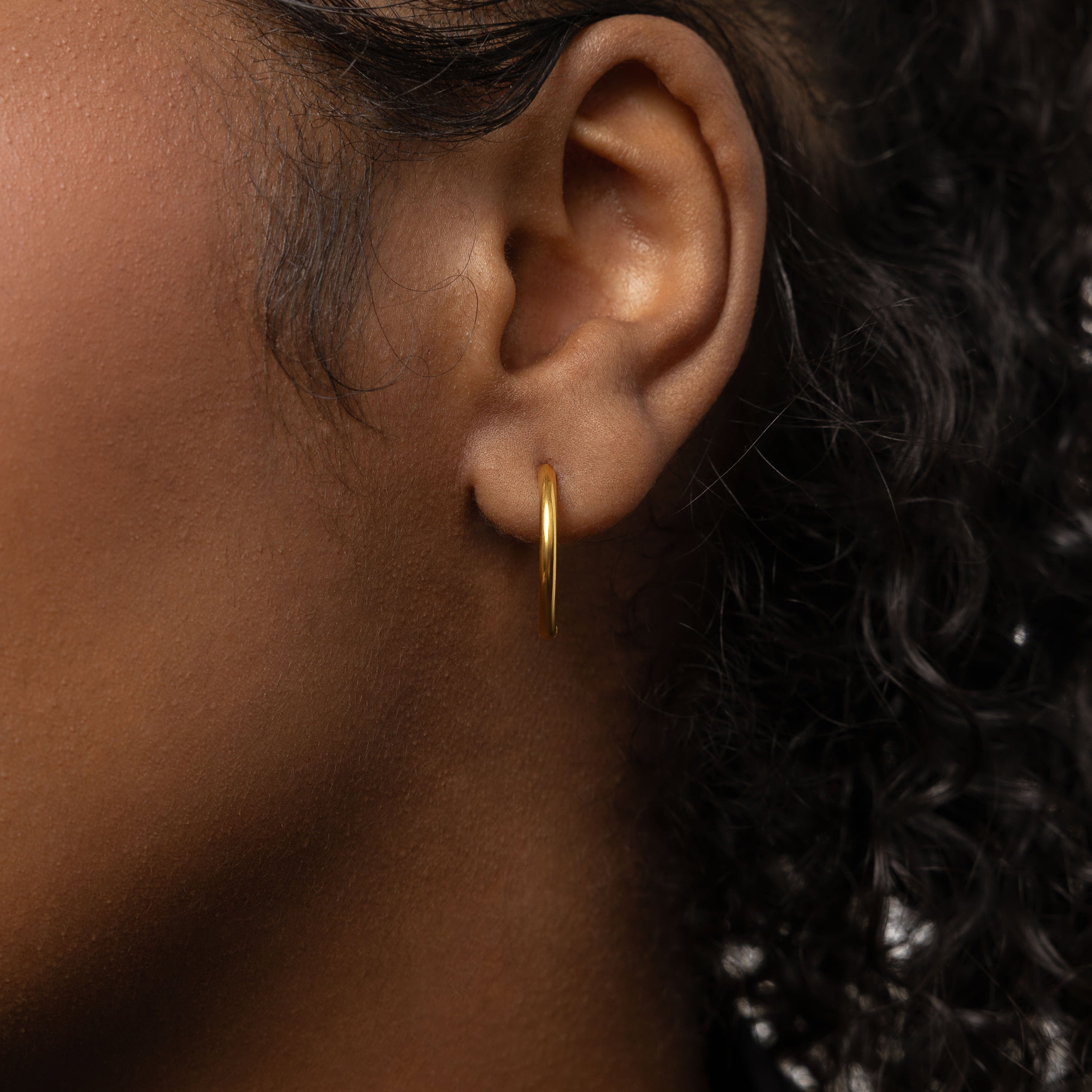 Close-up of the 16mm medium hoops worn, demonstrating their versatility with casual attire.