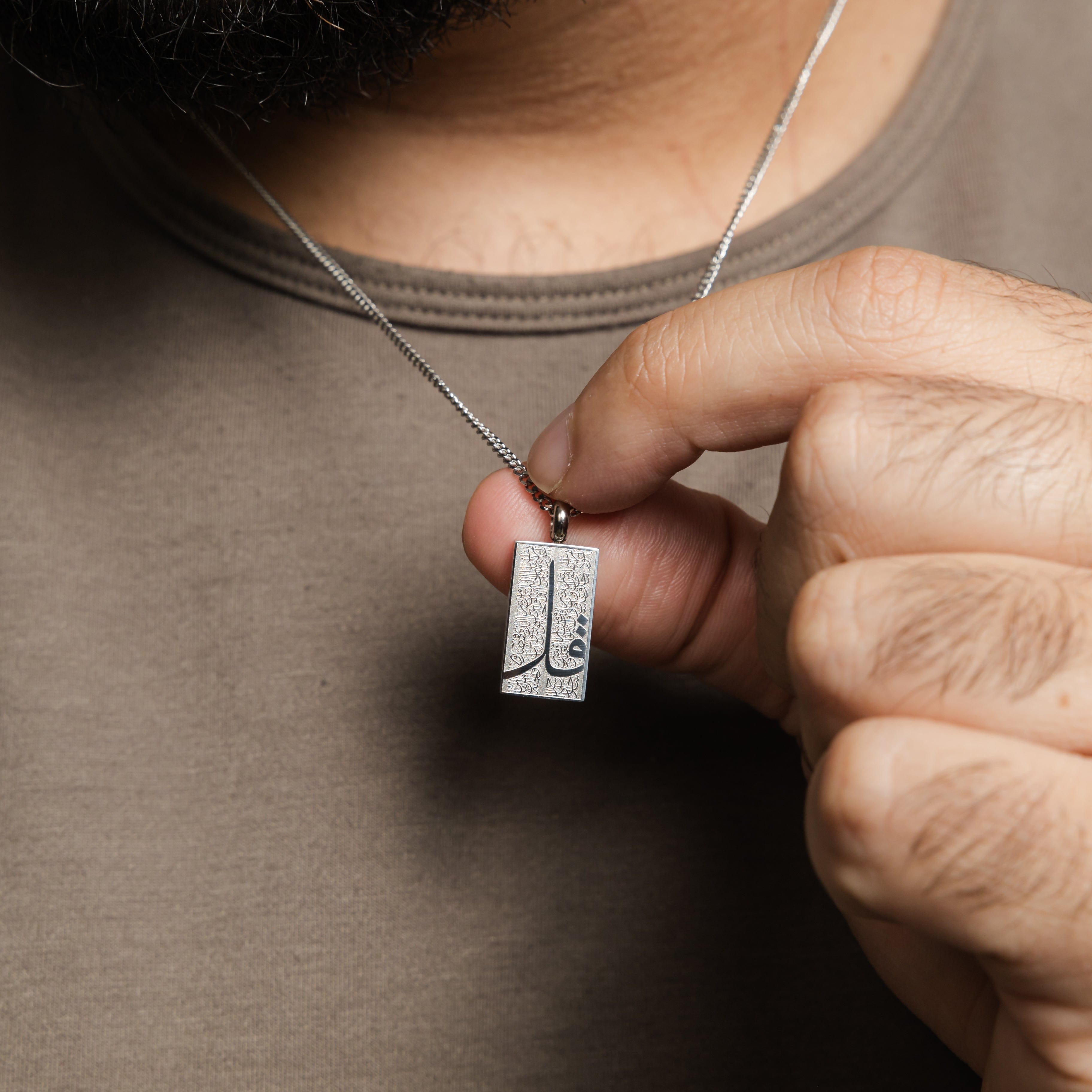 Man wearing the Four Qul necklace, highlighting its stylish look paired with casual attire.