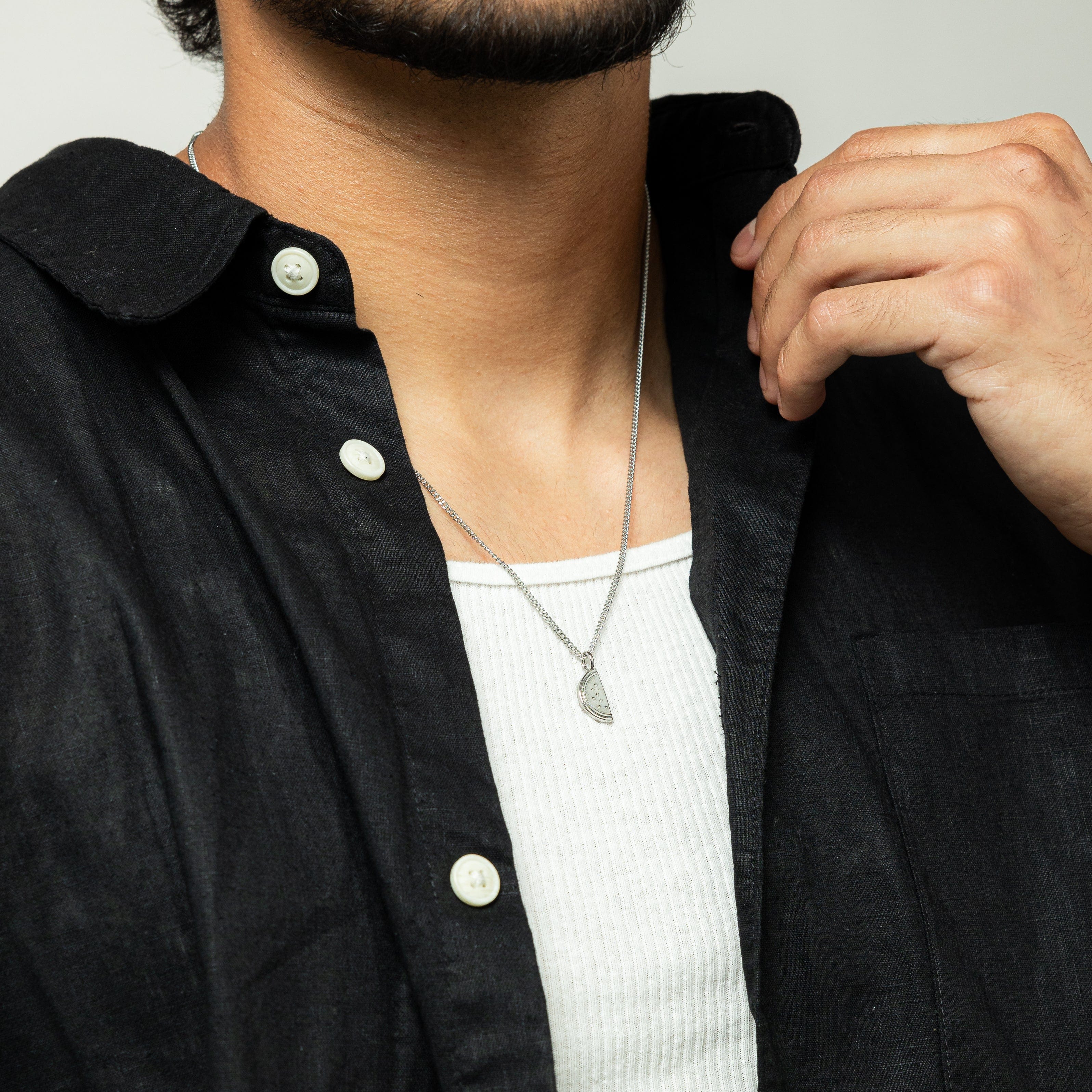 Man wearing the Palestinian watermelon necklace in casual attire, showcasing style and heritage.