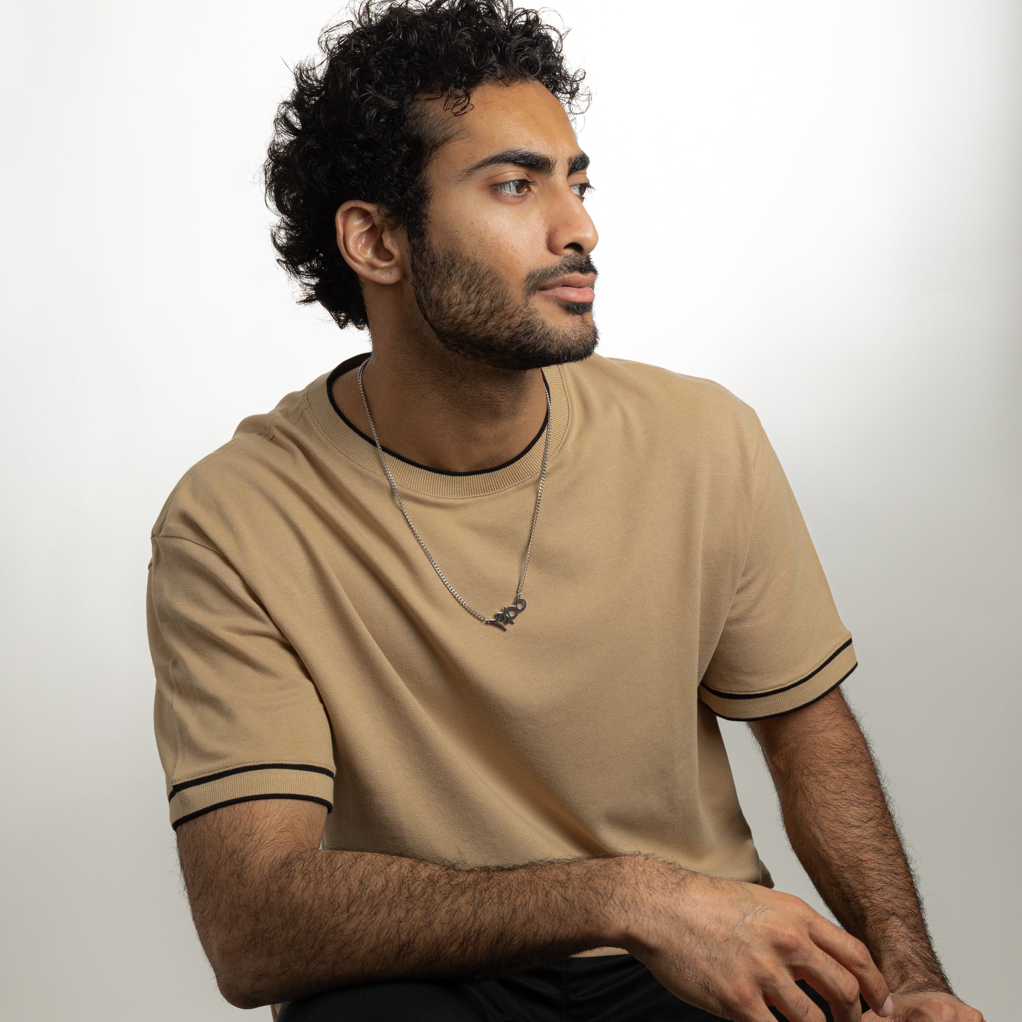 Ayatul Kursi necklace worn by a man, highlighting its stylish design and protective significance.
