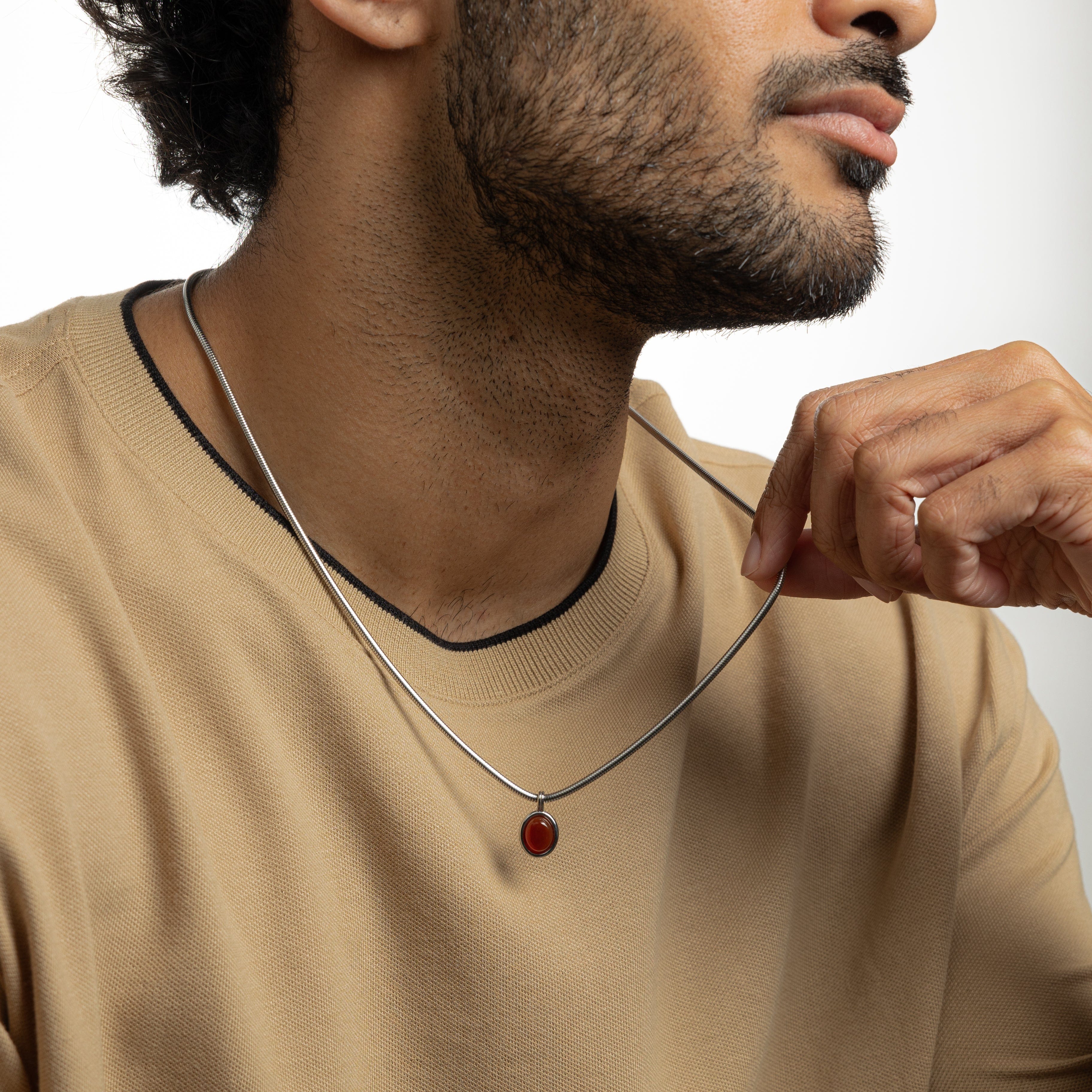 Close-up of the red agate stone in the steel pendant, highlighting its rich color and craftsmanship.