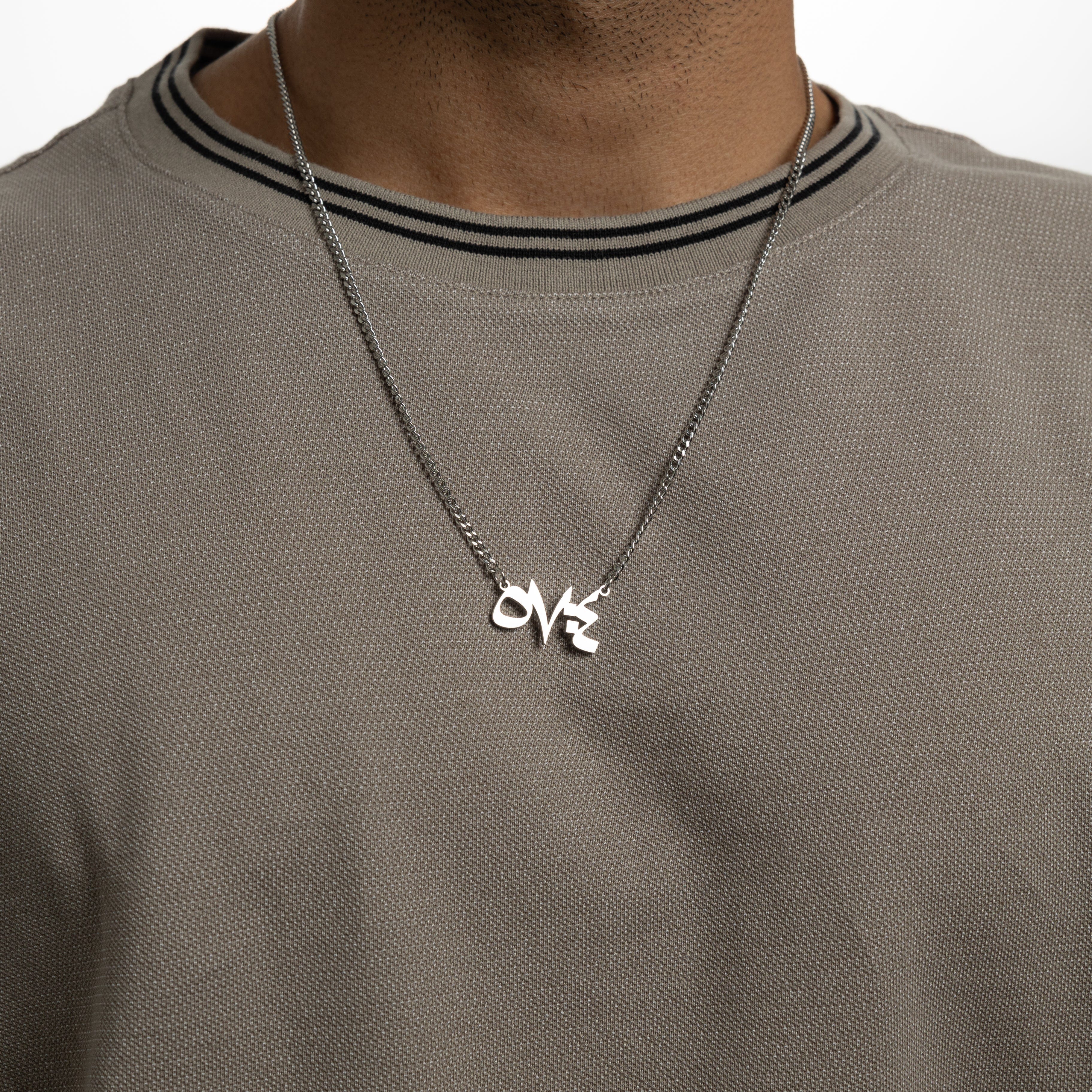 Model wearing a stainless steel necklace with a Quran verse, showcasing its everyday versatility.