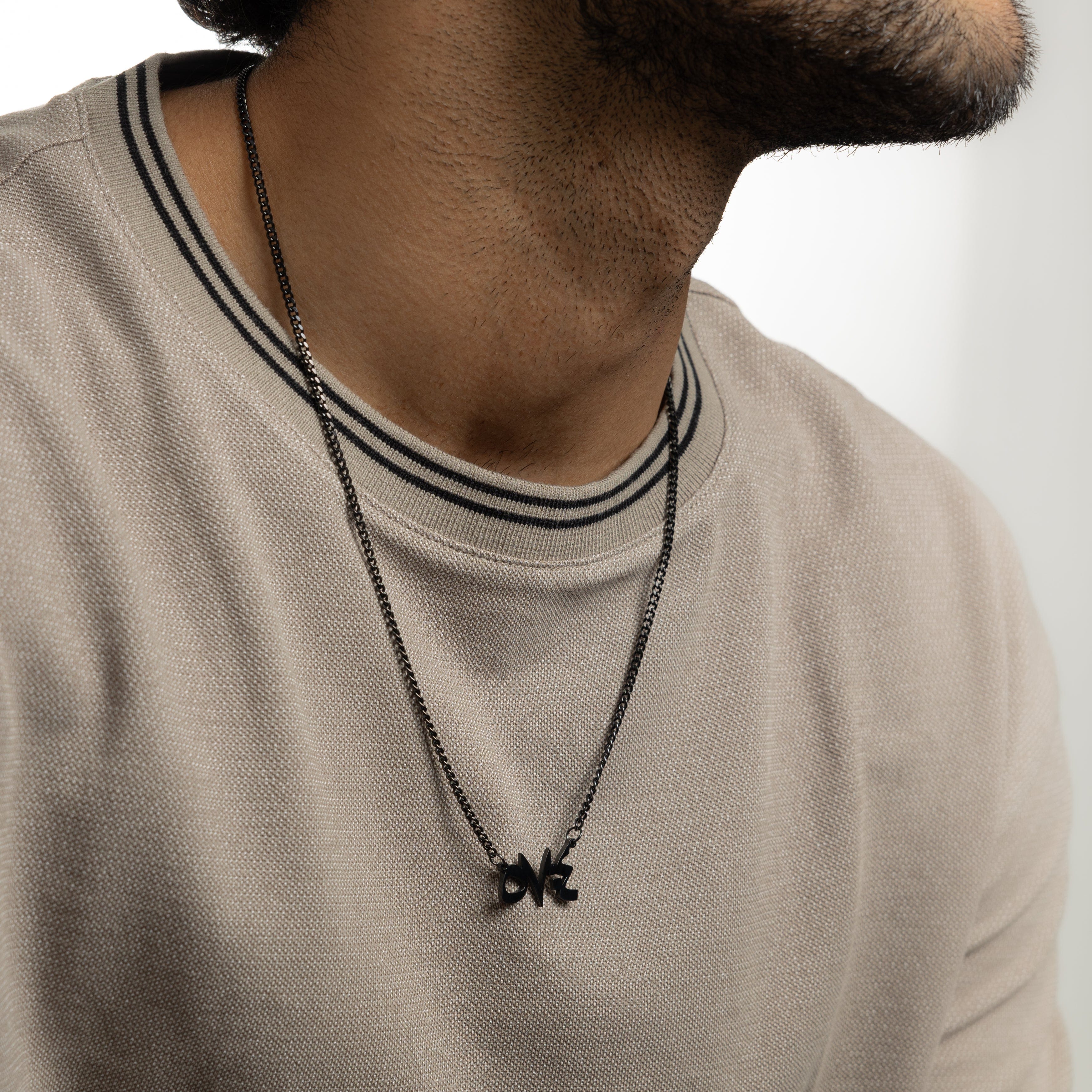 Model wearing a stainless steel necklace with a Quran verse, showcasing its everyday versatility.