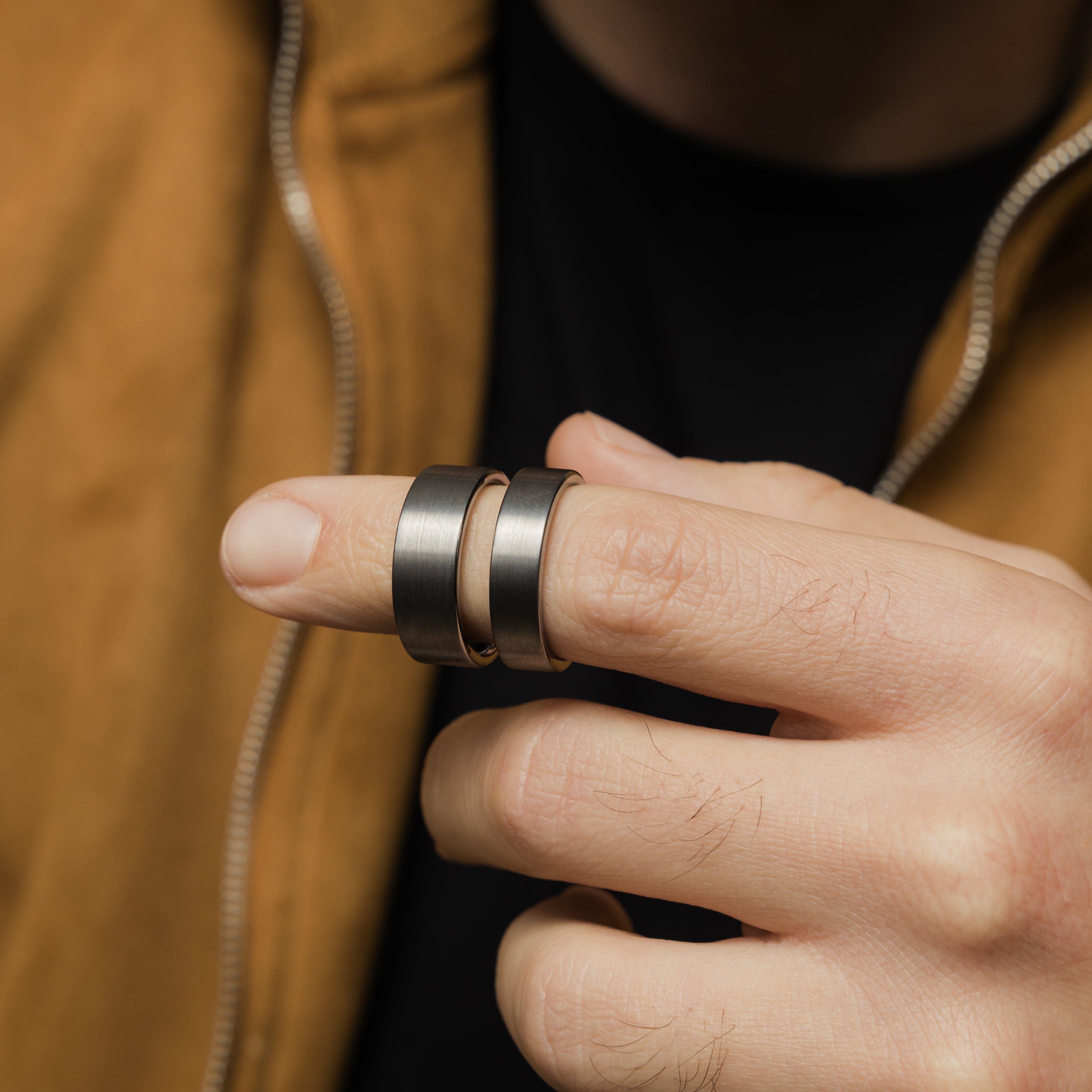 Flat tungsten band worn on a mans hand, highlighting its elegance.