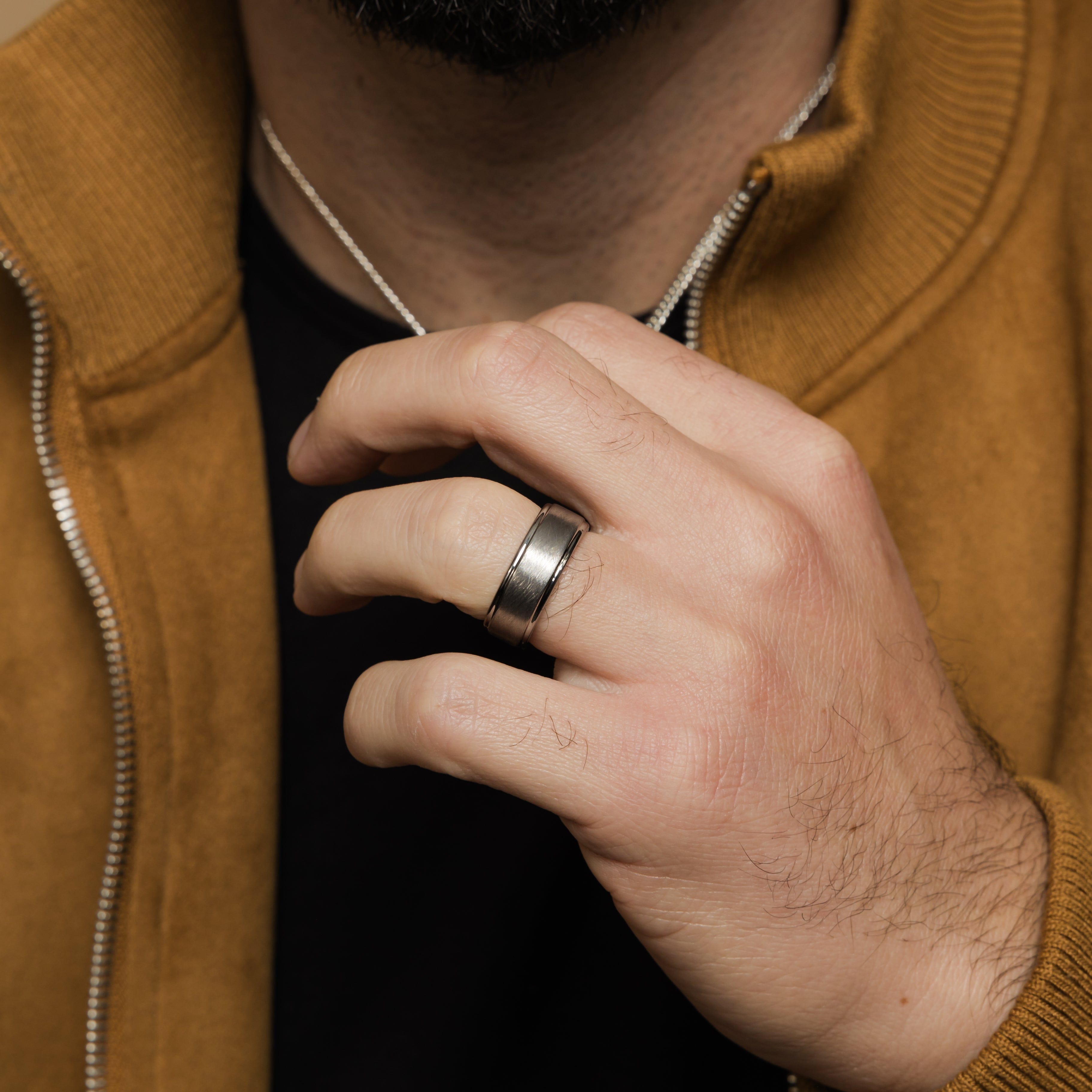 Textured tungsten wedding band worn on a mans hand, demonstrating its daily wear suitability.