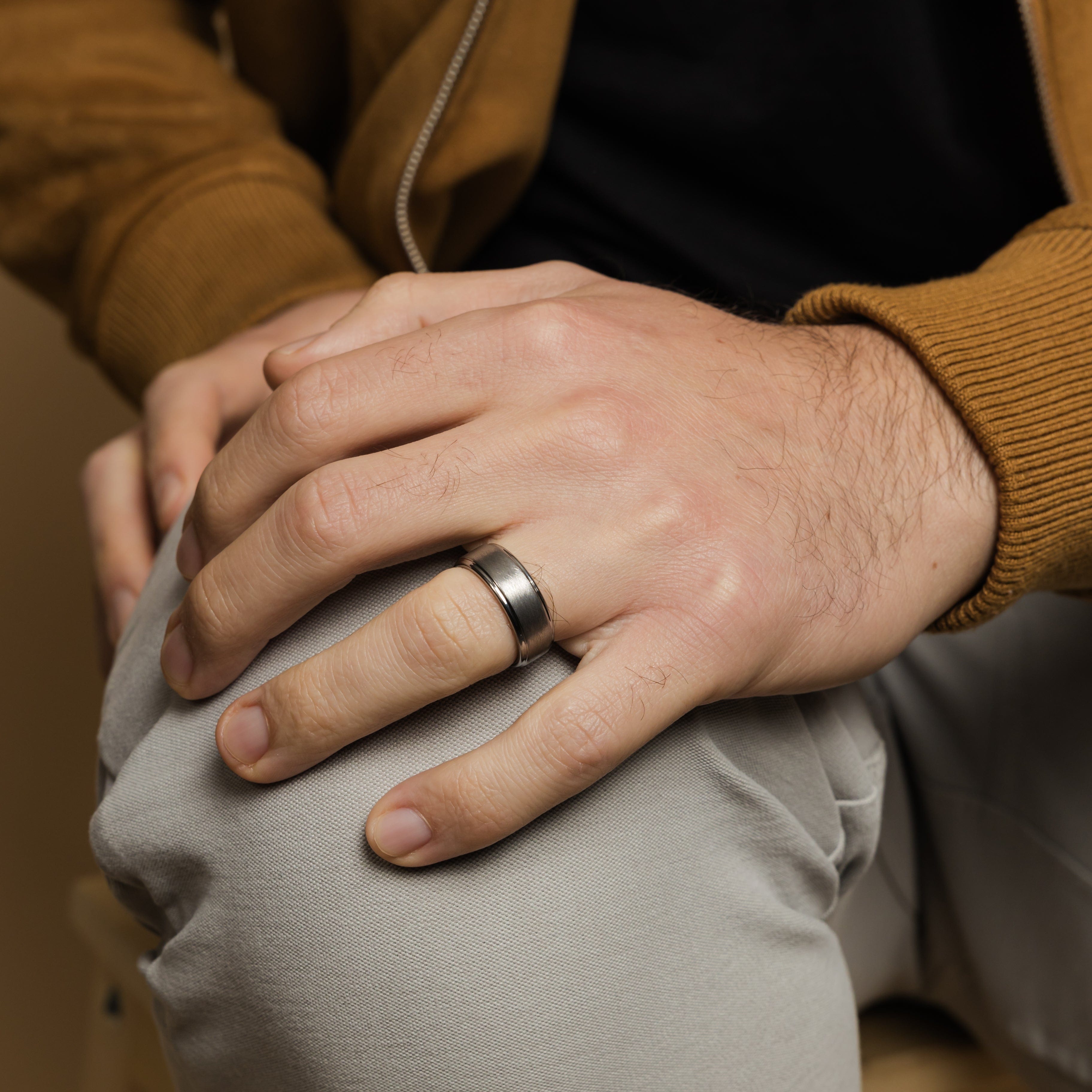 Close-up view of the textured tungsten wedding band, highlighting its rugged finish.