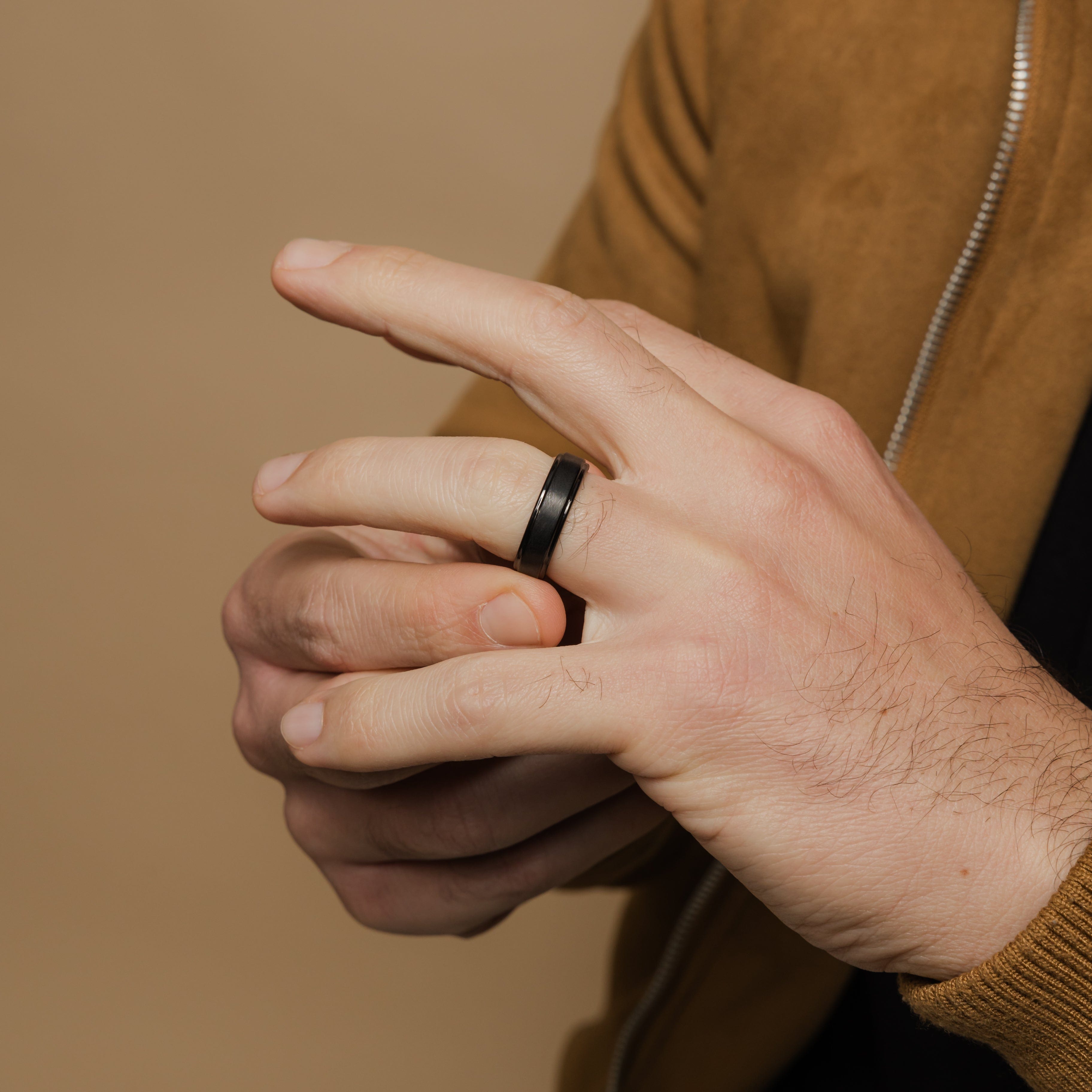 Display of the black and silver textured tungsten wedding bands side by side, showcasing color options.