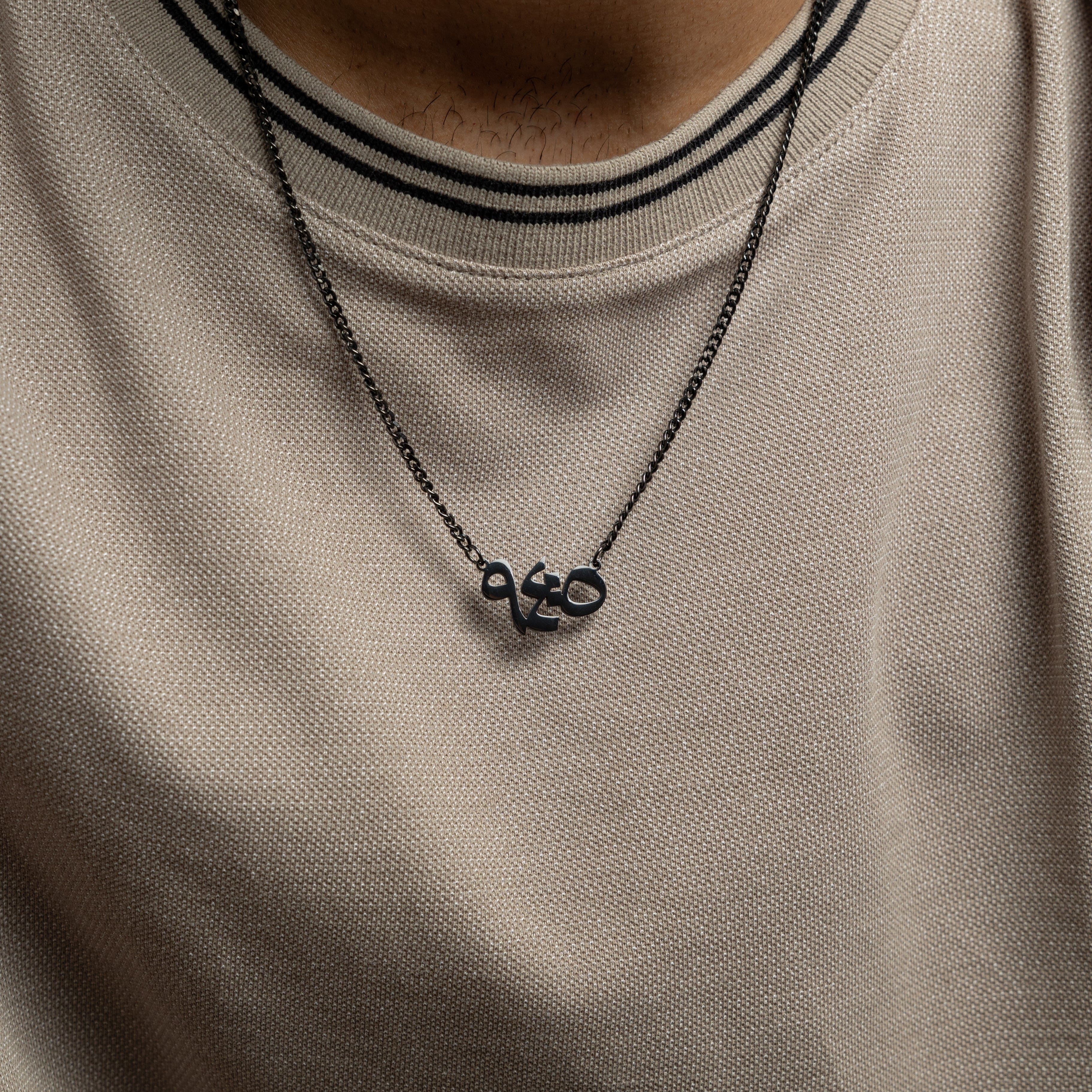 Mens stainless steel verse pendant with Arabic calligraphy showcasing With Hardship Comes Ease.