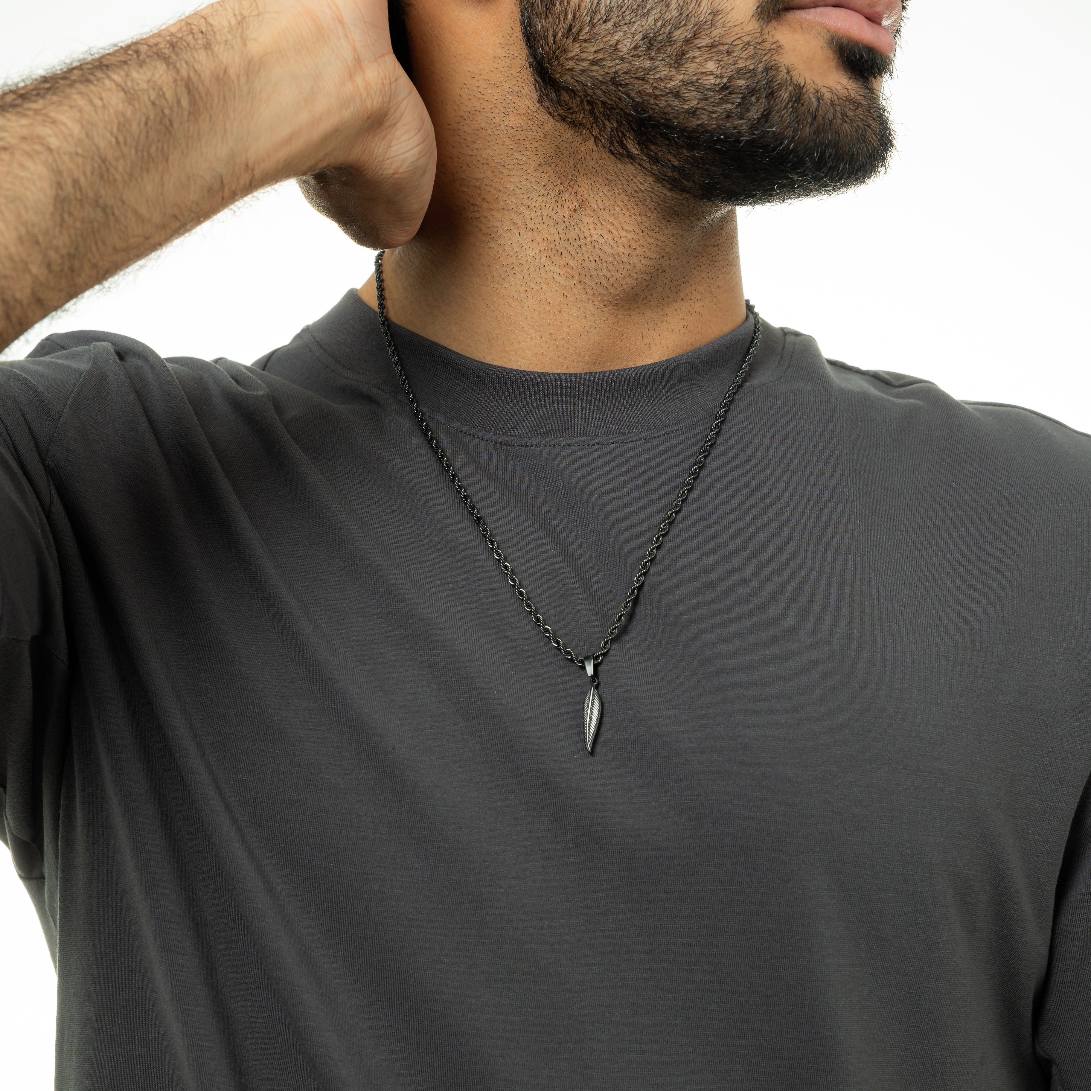 The feather necklace presented in its velvet drawstring pouch, ideal for gifting.