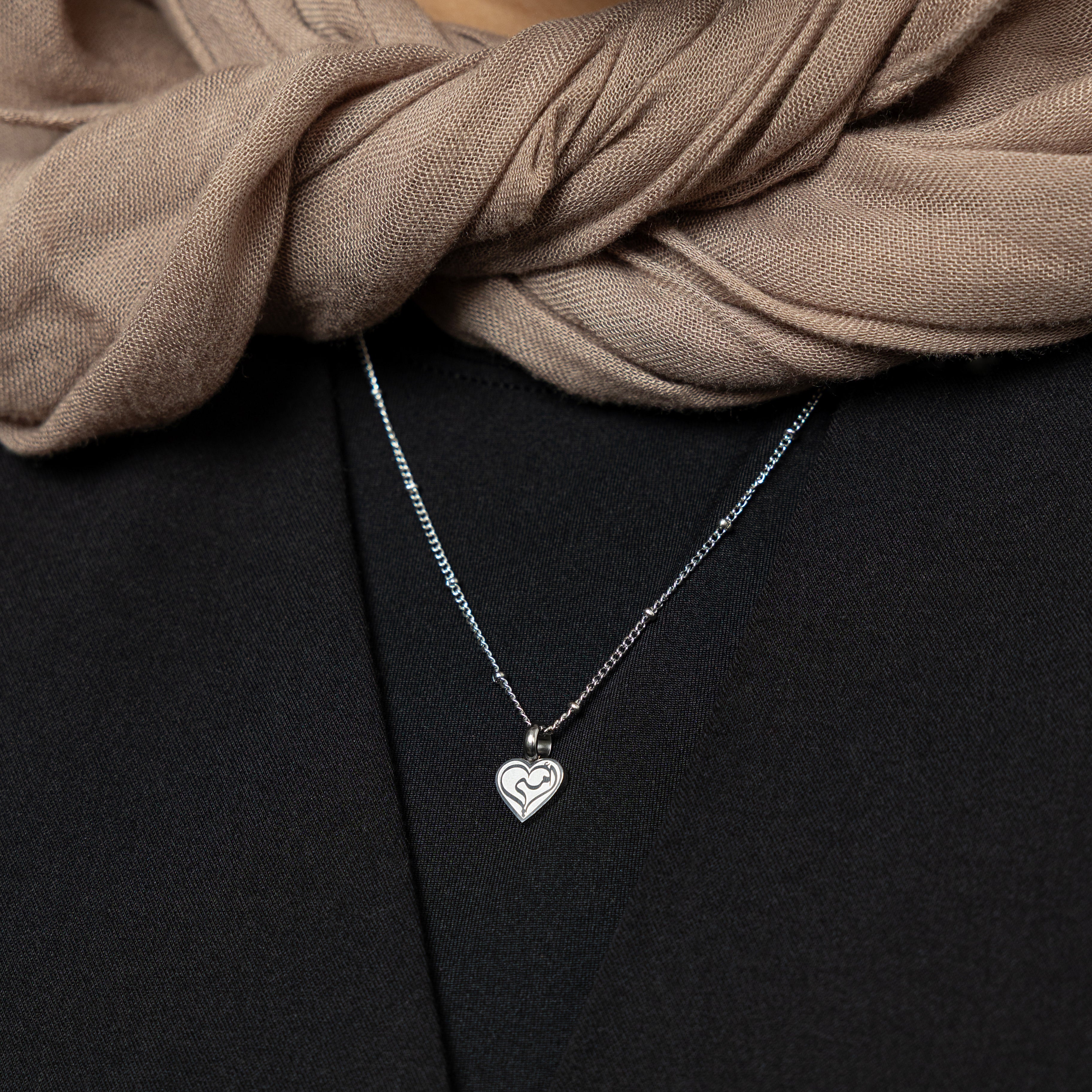 Close-up of minimalist heart charm necklace for mom, showcasing fine details of 18K gold-plated stainless steel and engraving.
