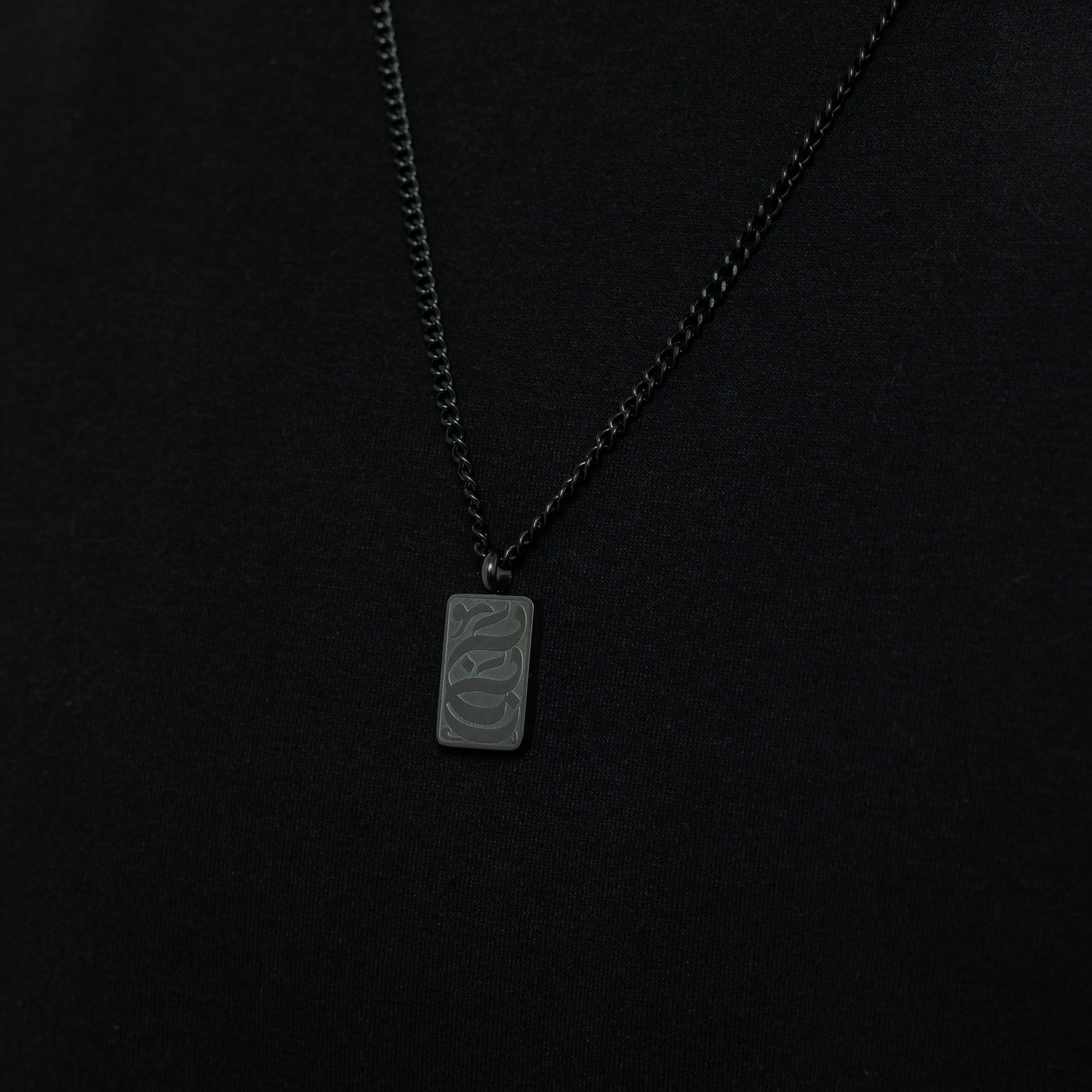 Close-up view of Baba engraved tag necklace showcasing Arabic engraving.