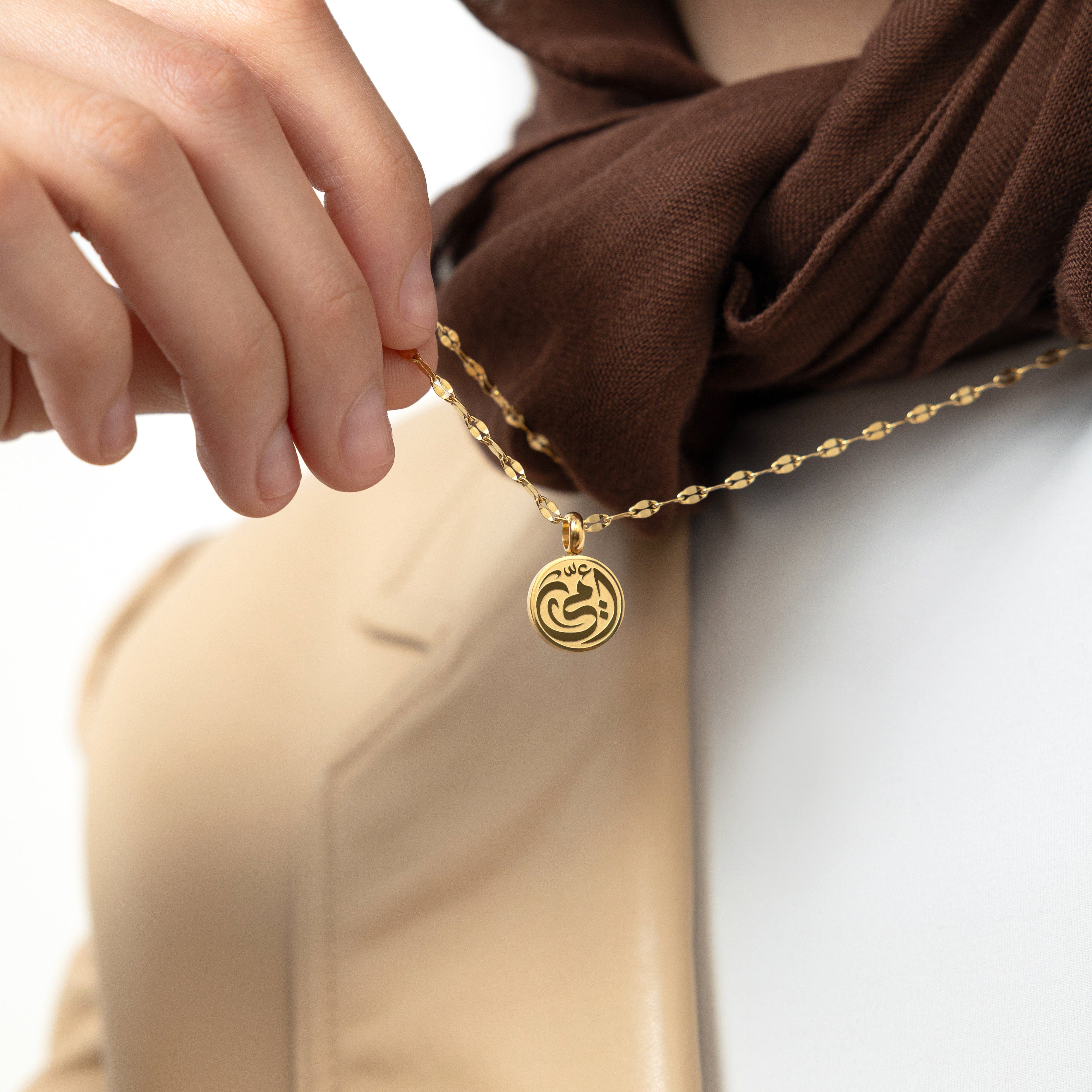 Close-up of the mother necklace pendant, highlighting the delicate Arabic etching and craftsmanship.