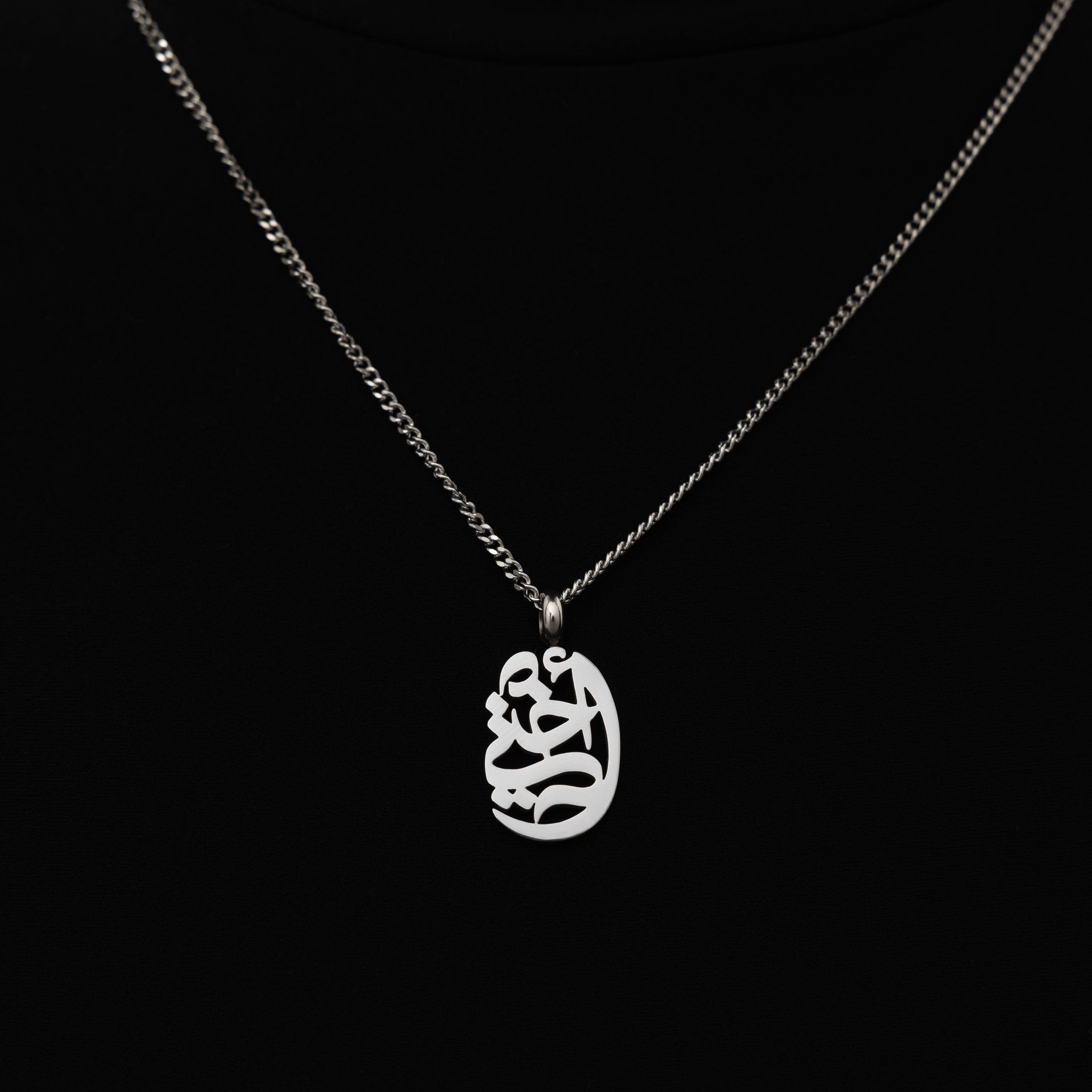 Close-up of Sisterly Love Gold Pendant Necklace featuring elegant Arabic calligraphy.