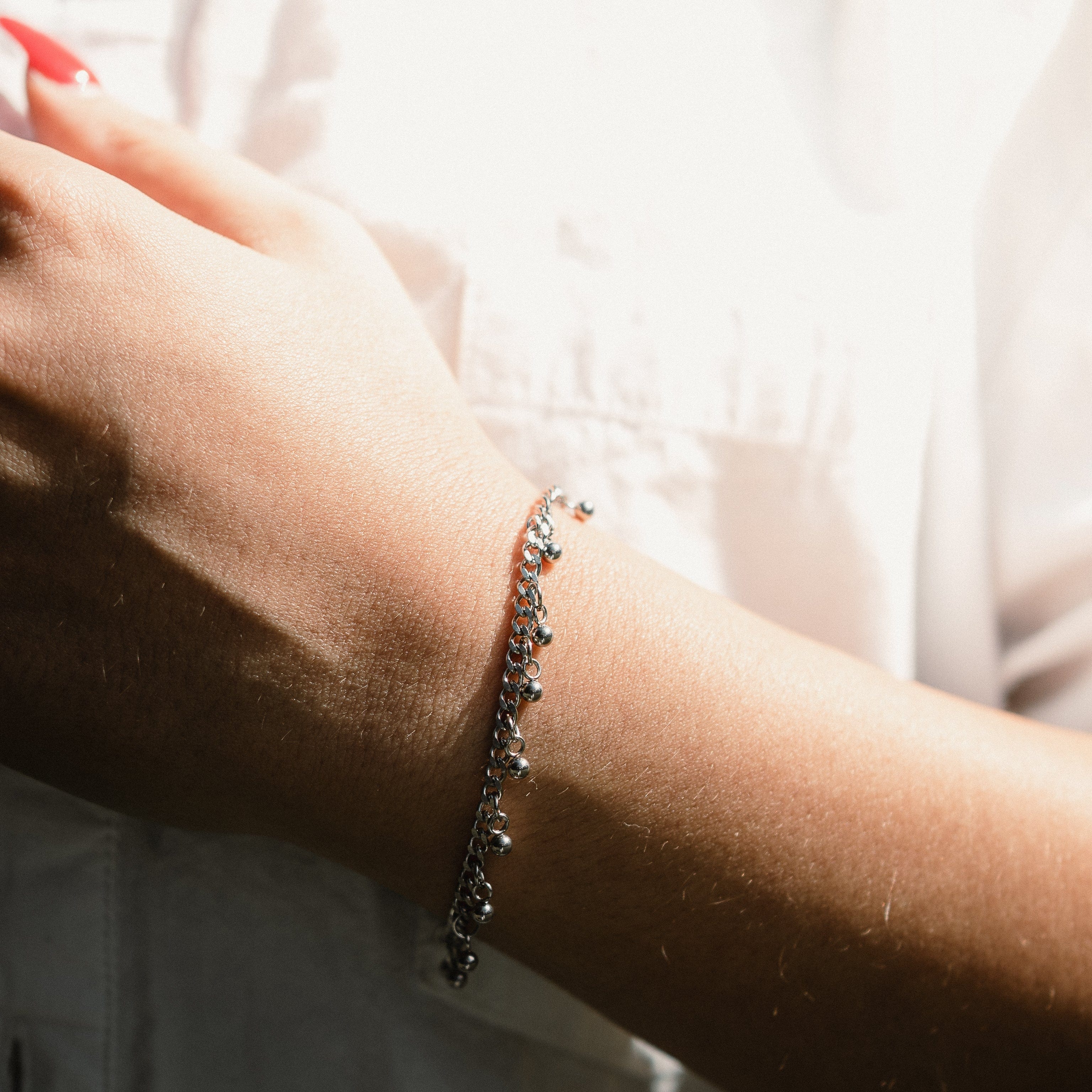 Elegant dotted charm bracelet with dangling charms, showcasing its intricate design.