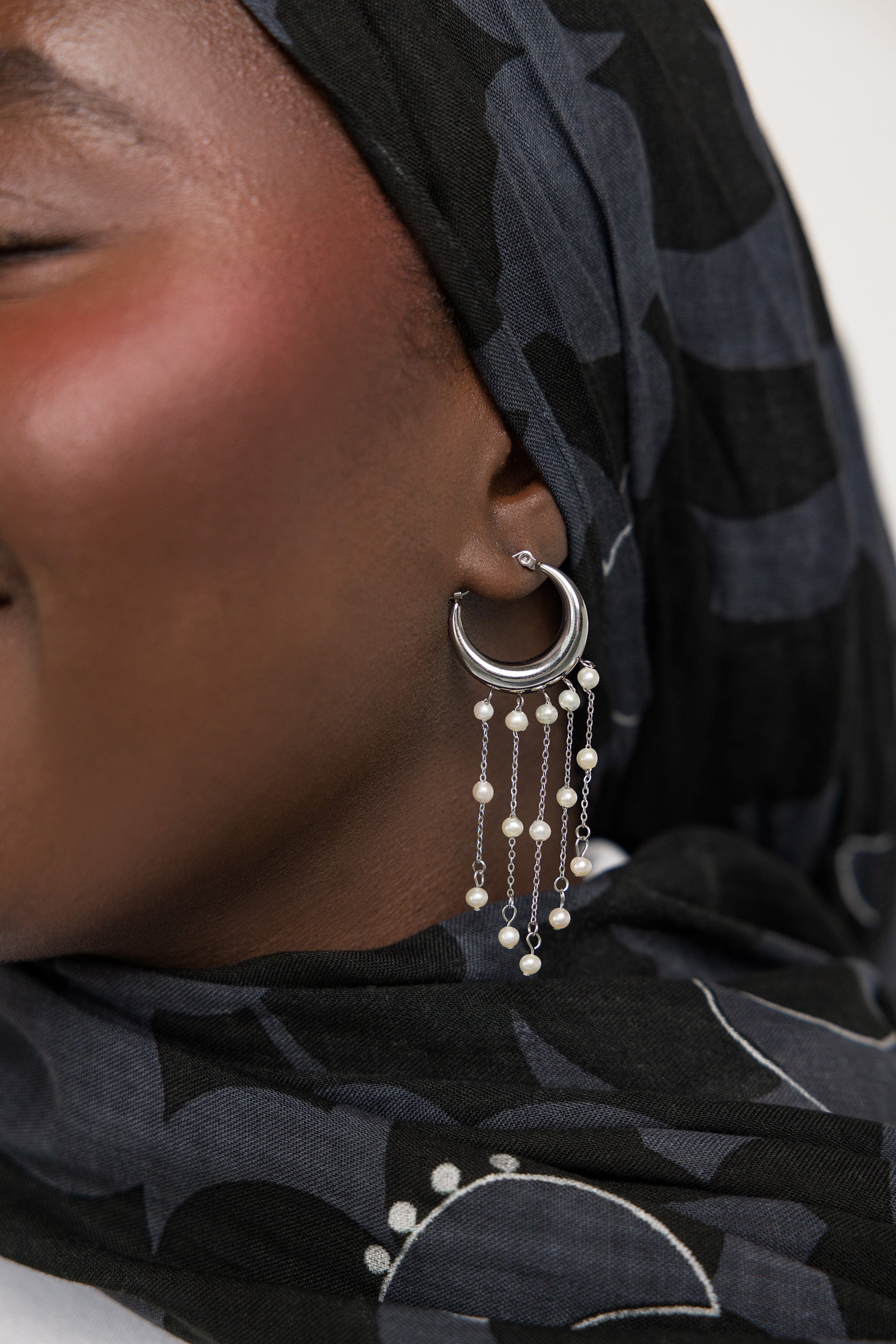 Close-up of celestial pearl cascade hoop earrings showcasing the gold and freshwater pearls.