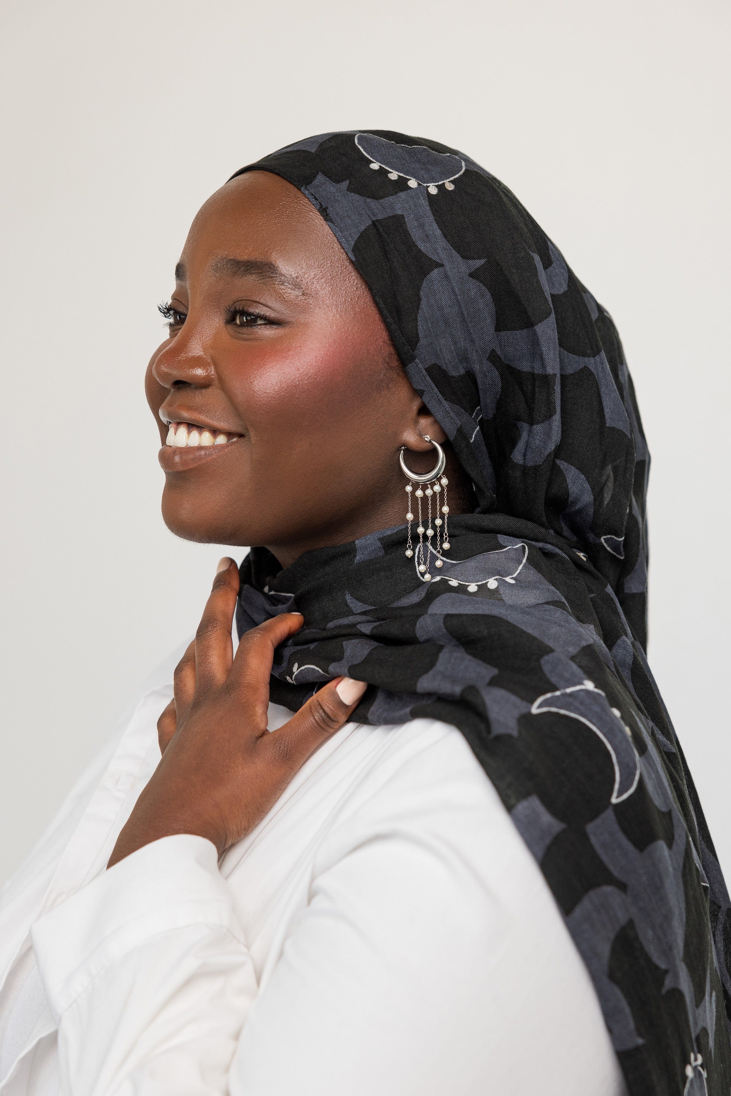 Flat lay of celestial pearl hoop earrings on a soft fabric background, emphasizing their delicate design.