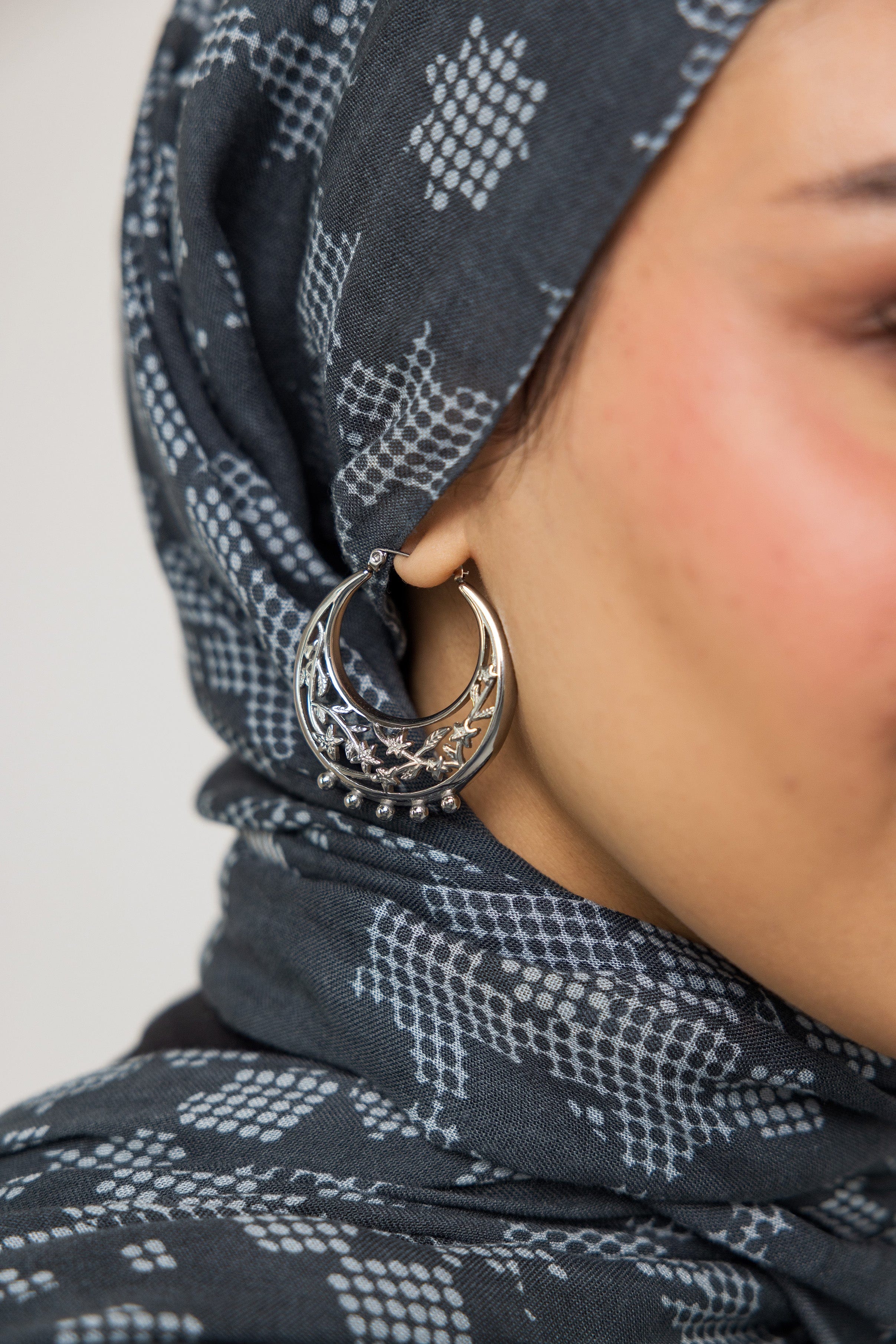 Celestial jasmine gold hoop earrings showcasing intricate design from the side.