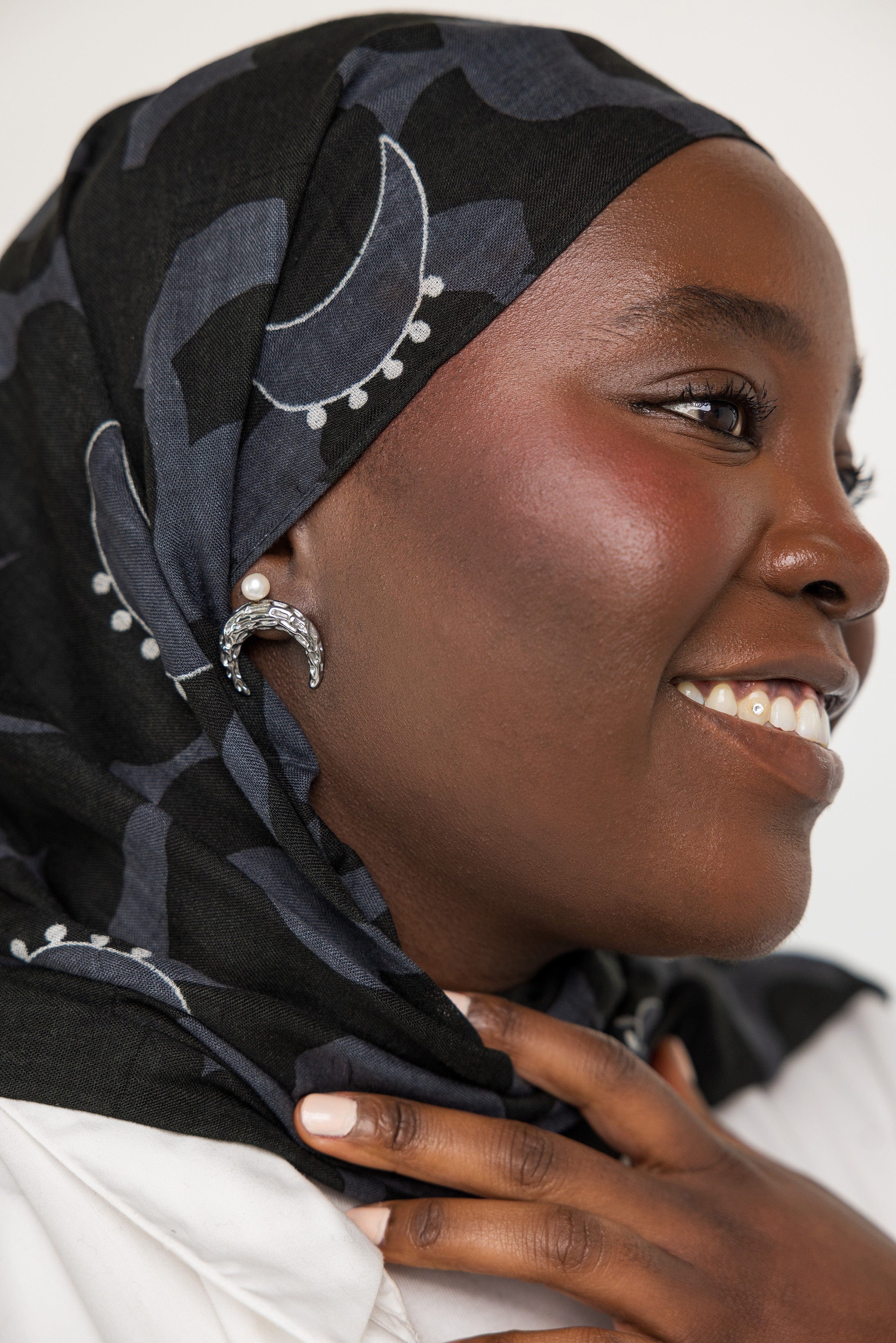 Close-up of the Cascading Pearl Crescent Earrings highlighting the hammered texture and 18K gold plating.