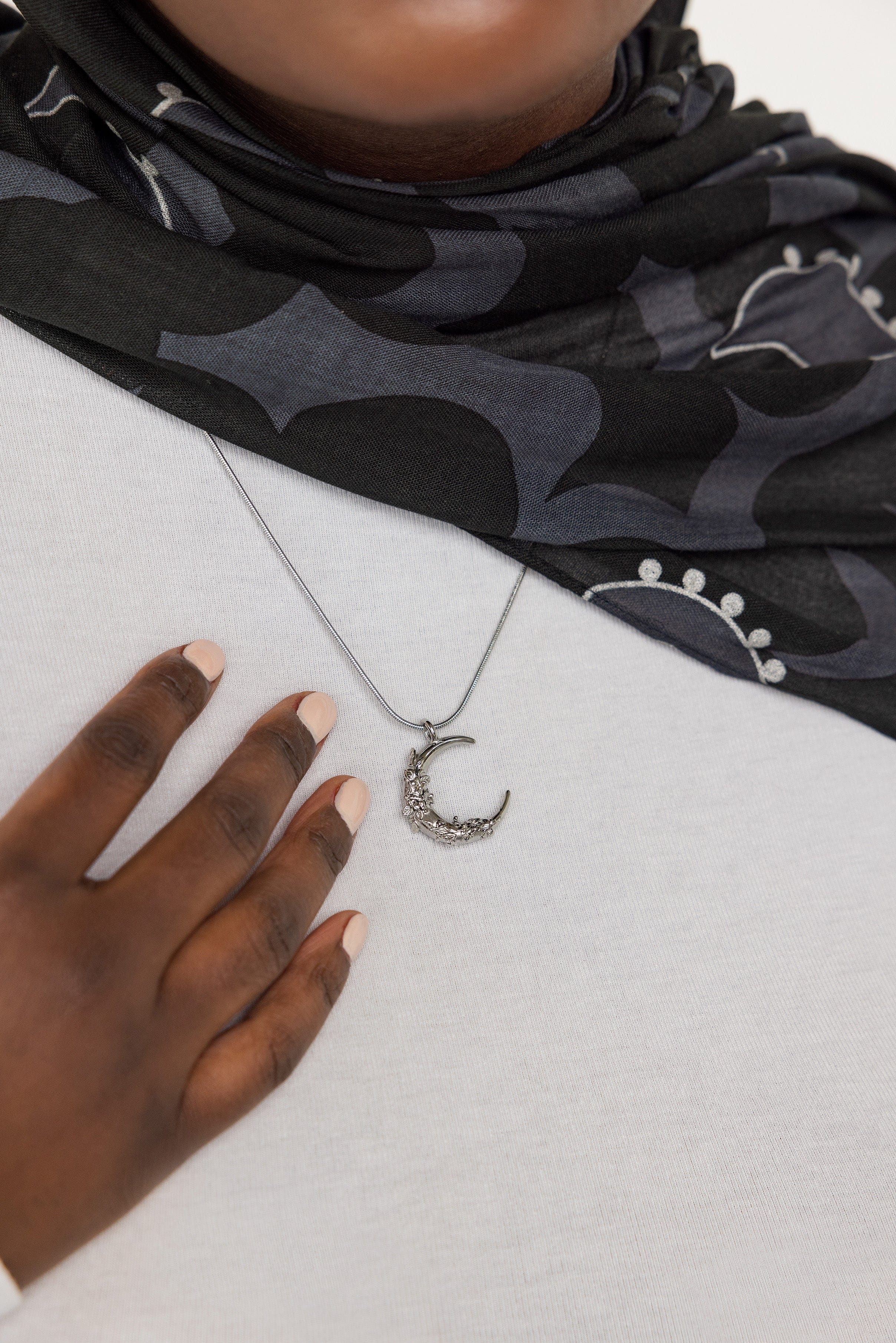 Close-up view of the celestial jasmine crescent pendant necklace highlighting intricate details.