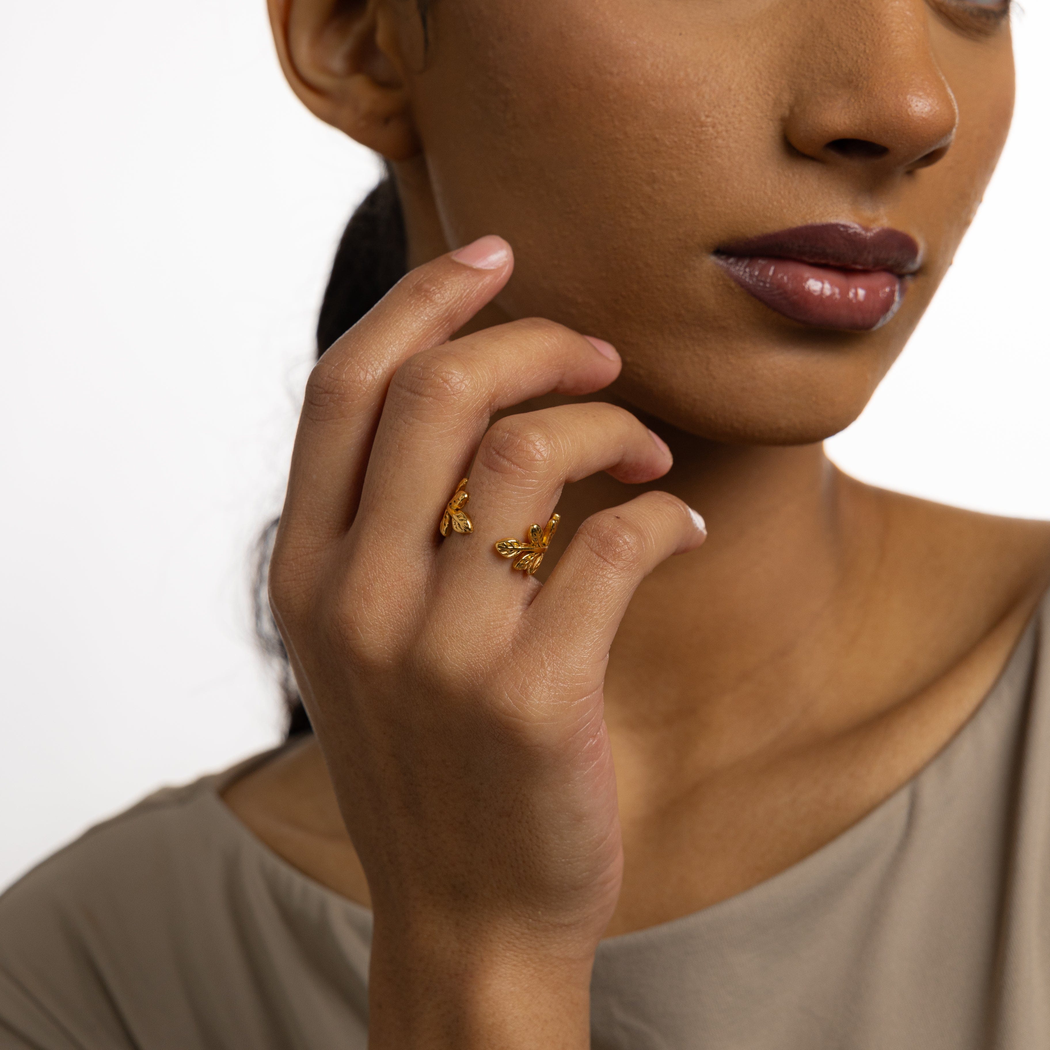 Stylish woman wearing the olive branch ring in a natural setting, representing strength and confidence.
