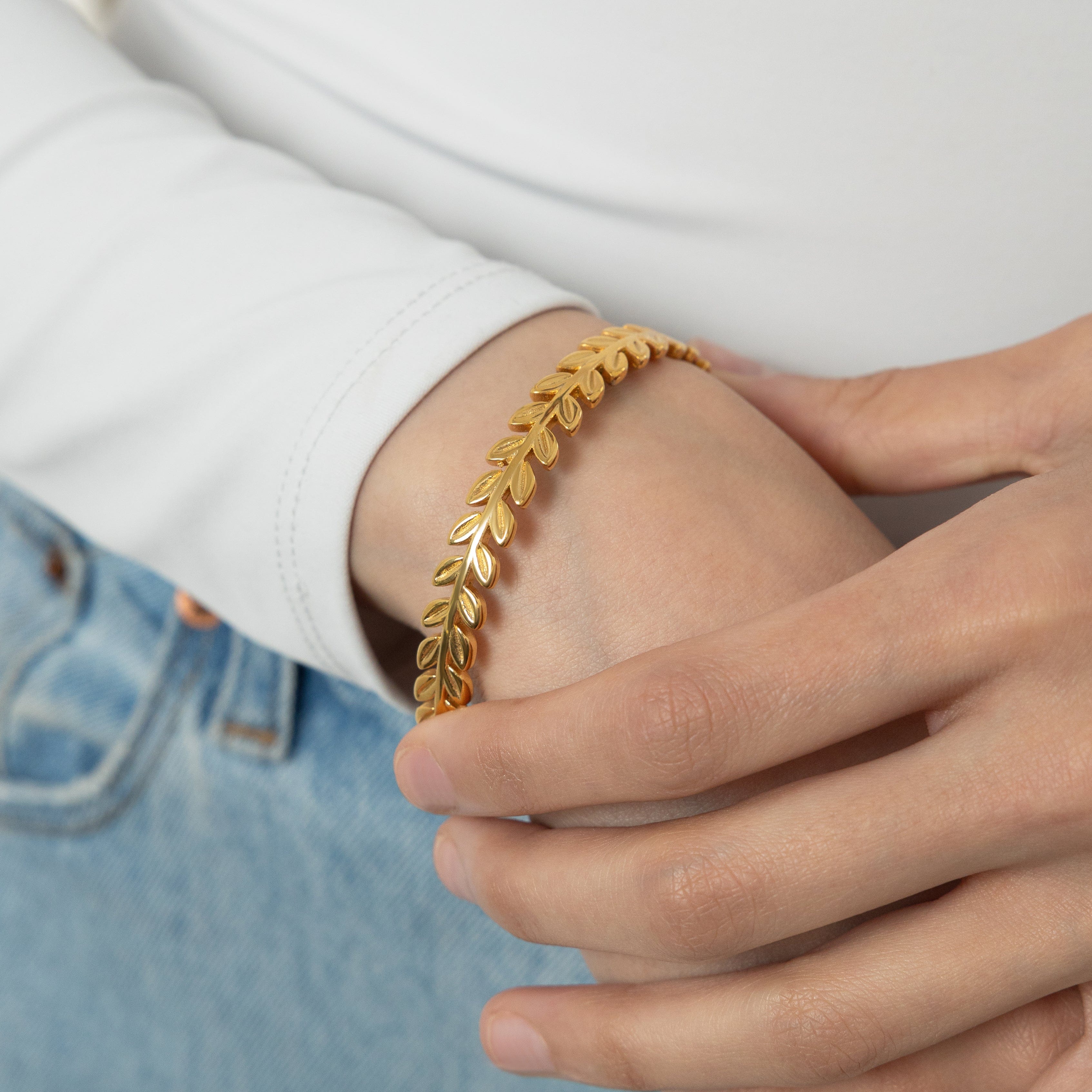 Close-up of the gold plated olive branch bangle highlighting its sleek finish.
