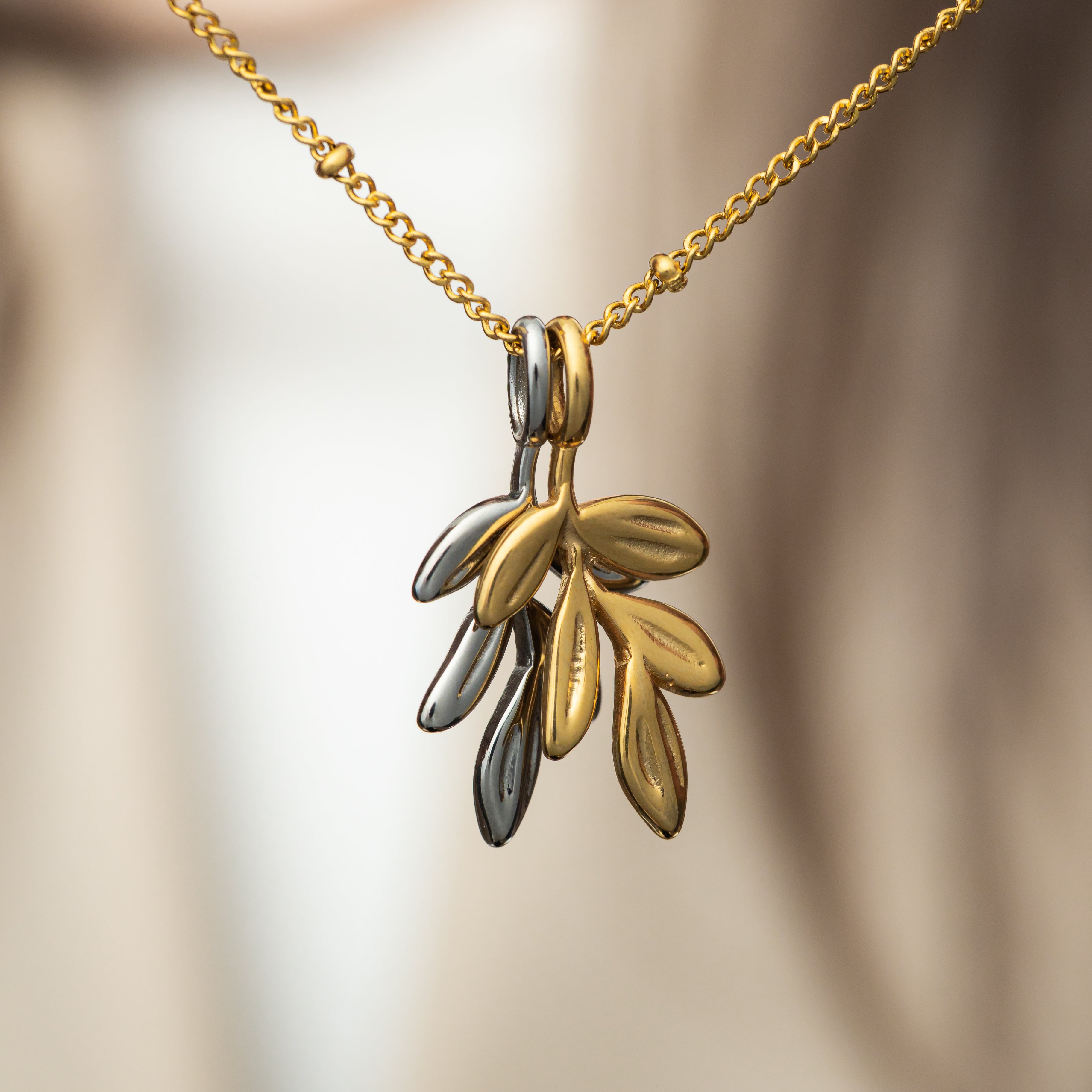 Close-up of the Timeless Olive Branch Gold Charm highlighting its intricate design.