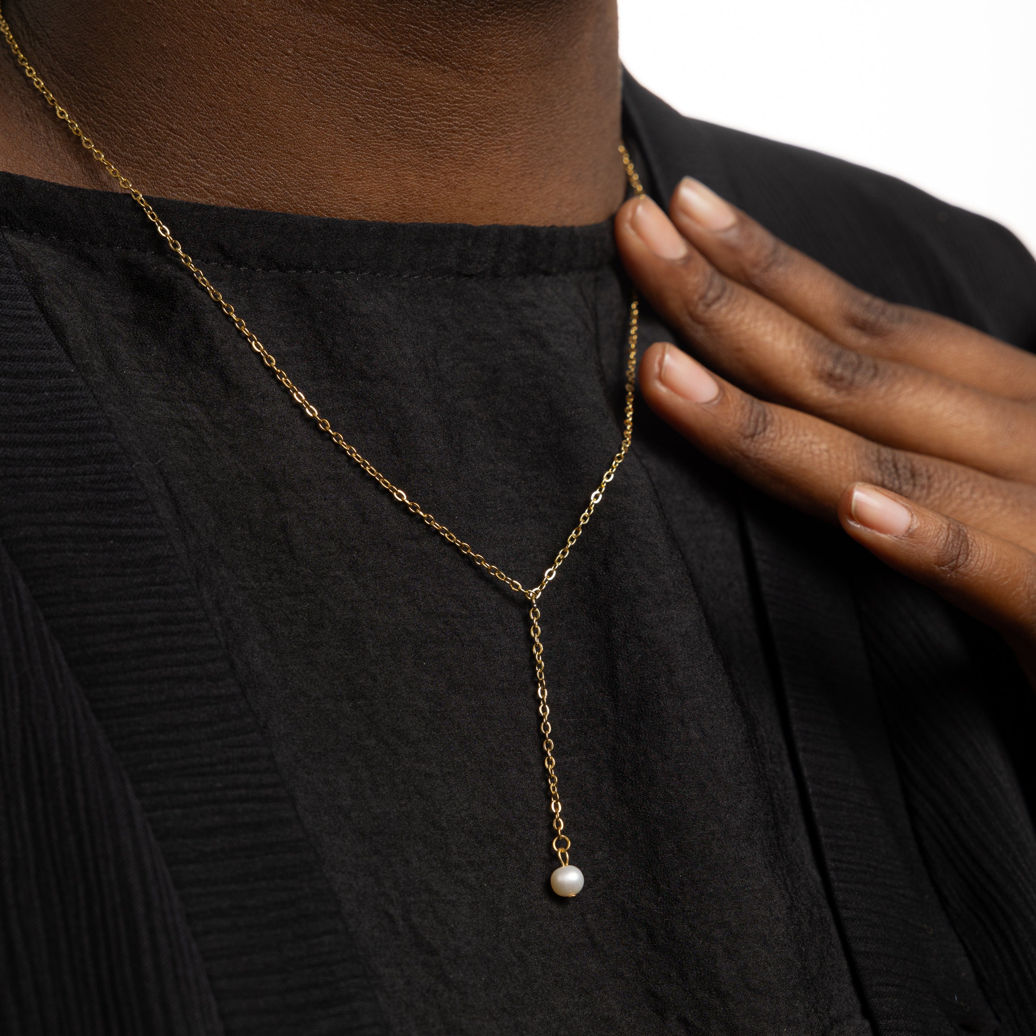 Luxury gold pearl necklace with lariat design, highlighting the stunning freshwater pearl
