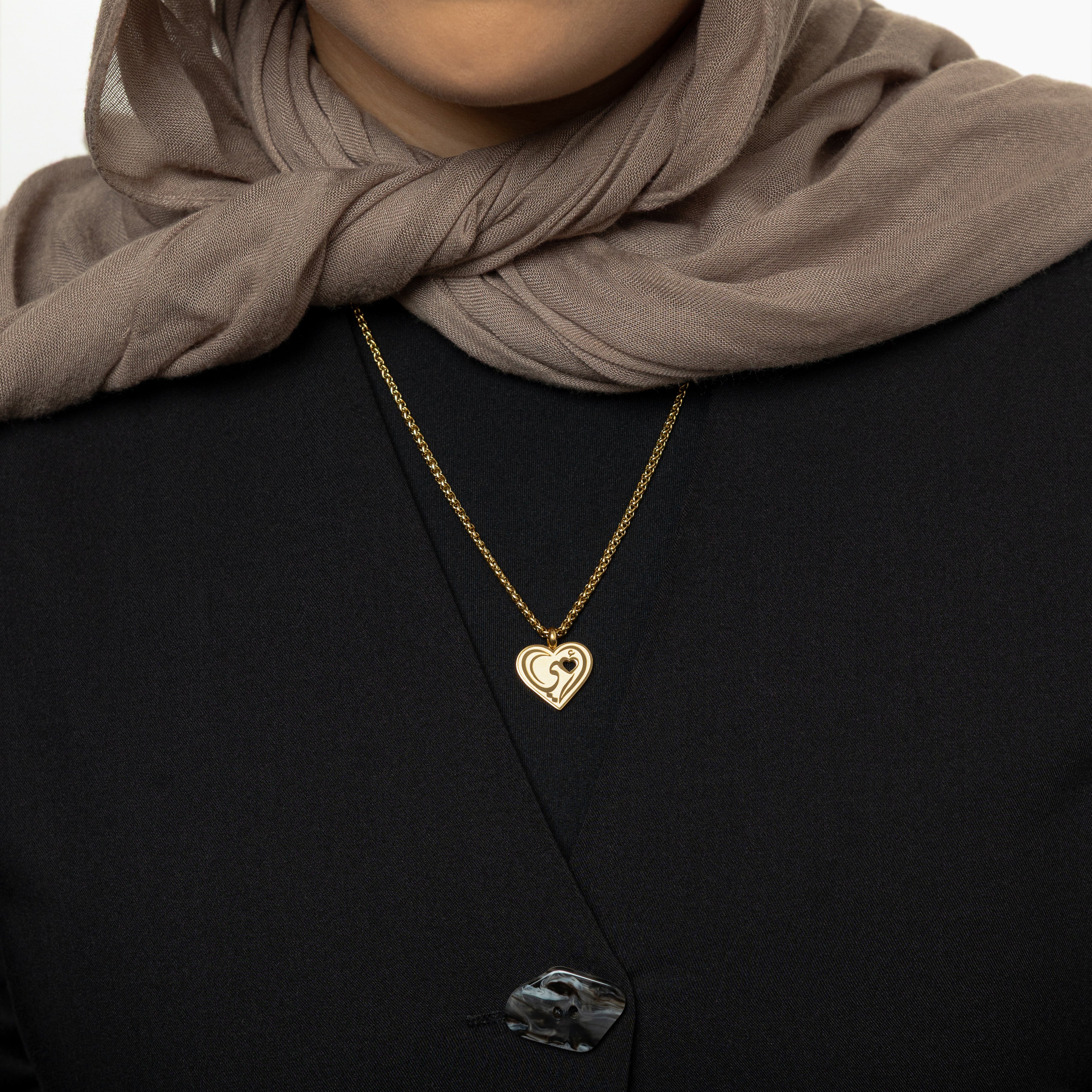 Heartfelt Mama Necklace displayed elegantly on a velvet pouch, showcasing its Arabic calligraphy.