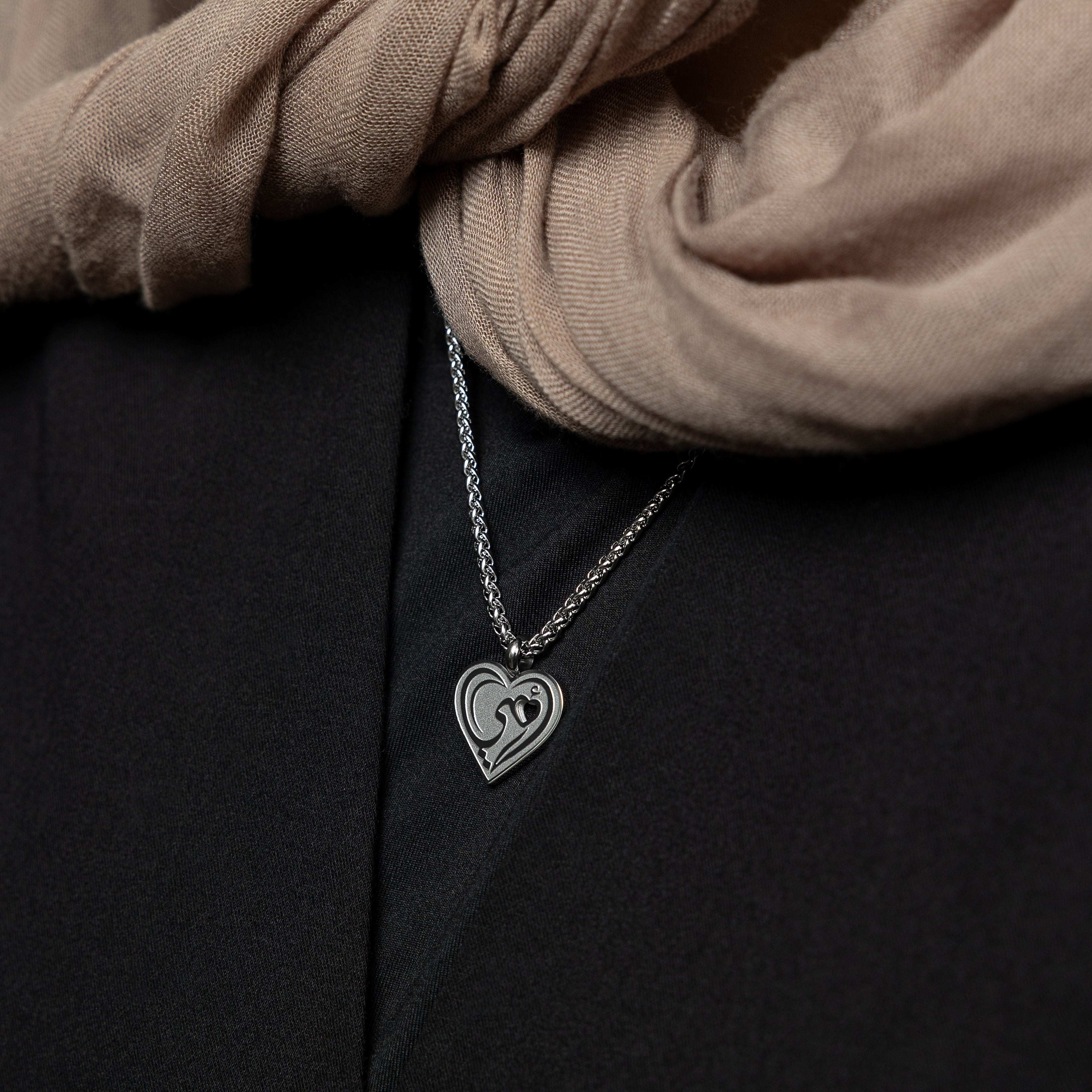 Heartfelt Mama Necklace displayed elegantly on a velvet pouch, showcasing its Arabic calligraphy.