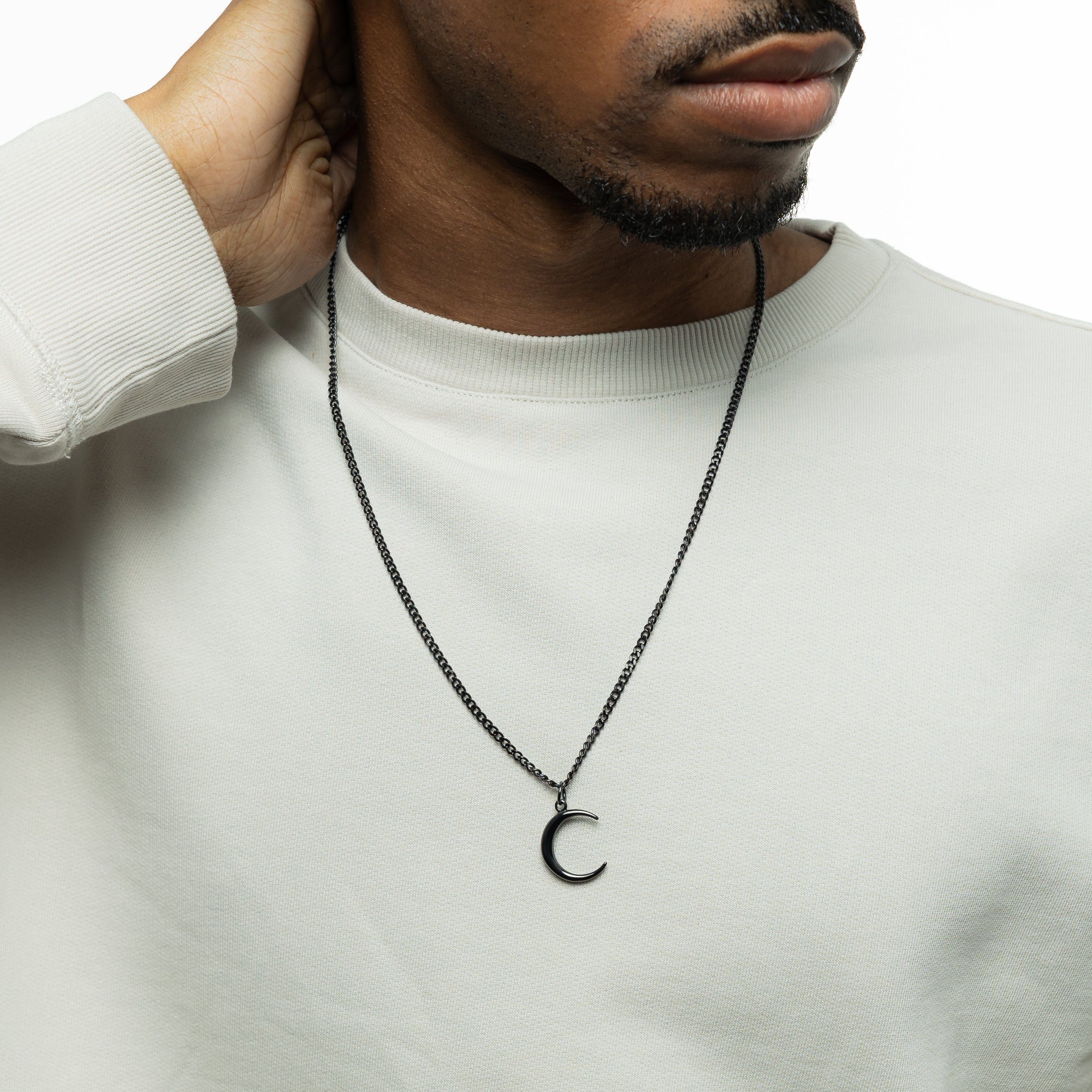 The crescent necklace worn by a model, showcasing its elegance and versatility.